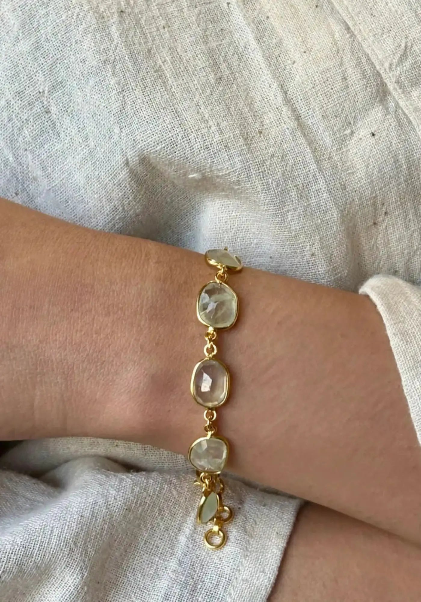 La femme porte le bracelet Rati Knots vert préhnite de chez Ekadori