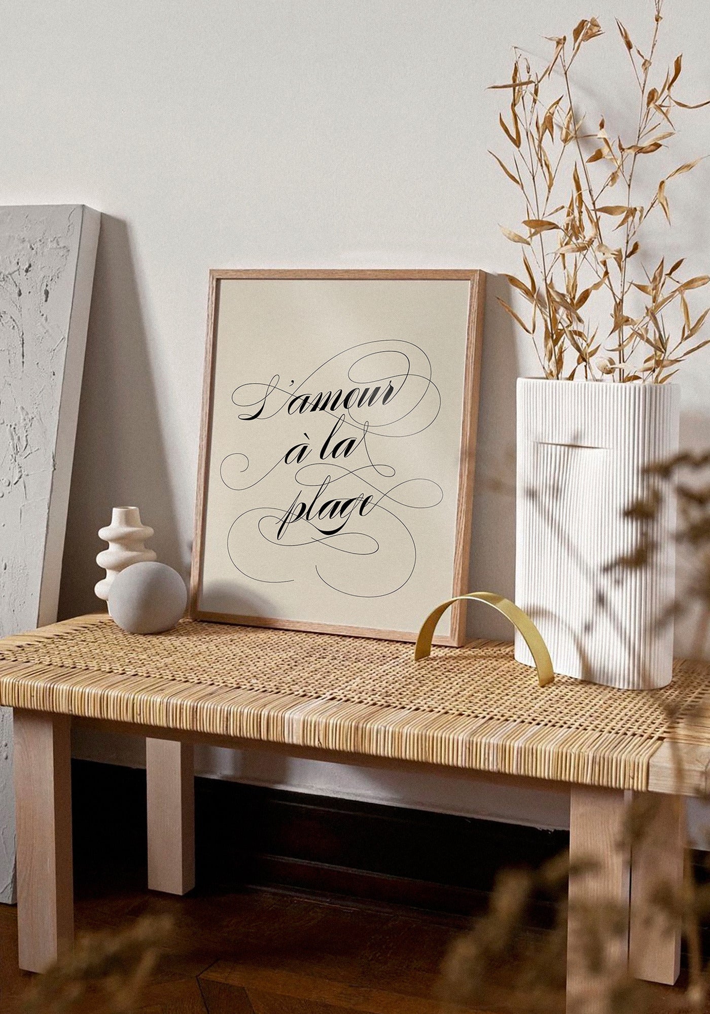 L'affiche typographique "L'amour à la plage" en 21x30 cm de chez Studio Topo posée sur un banc en bois