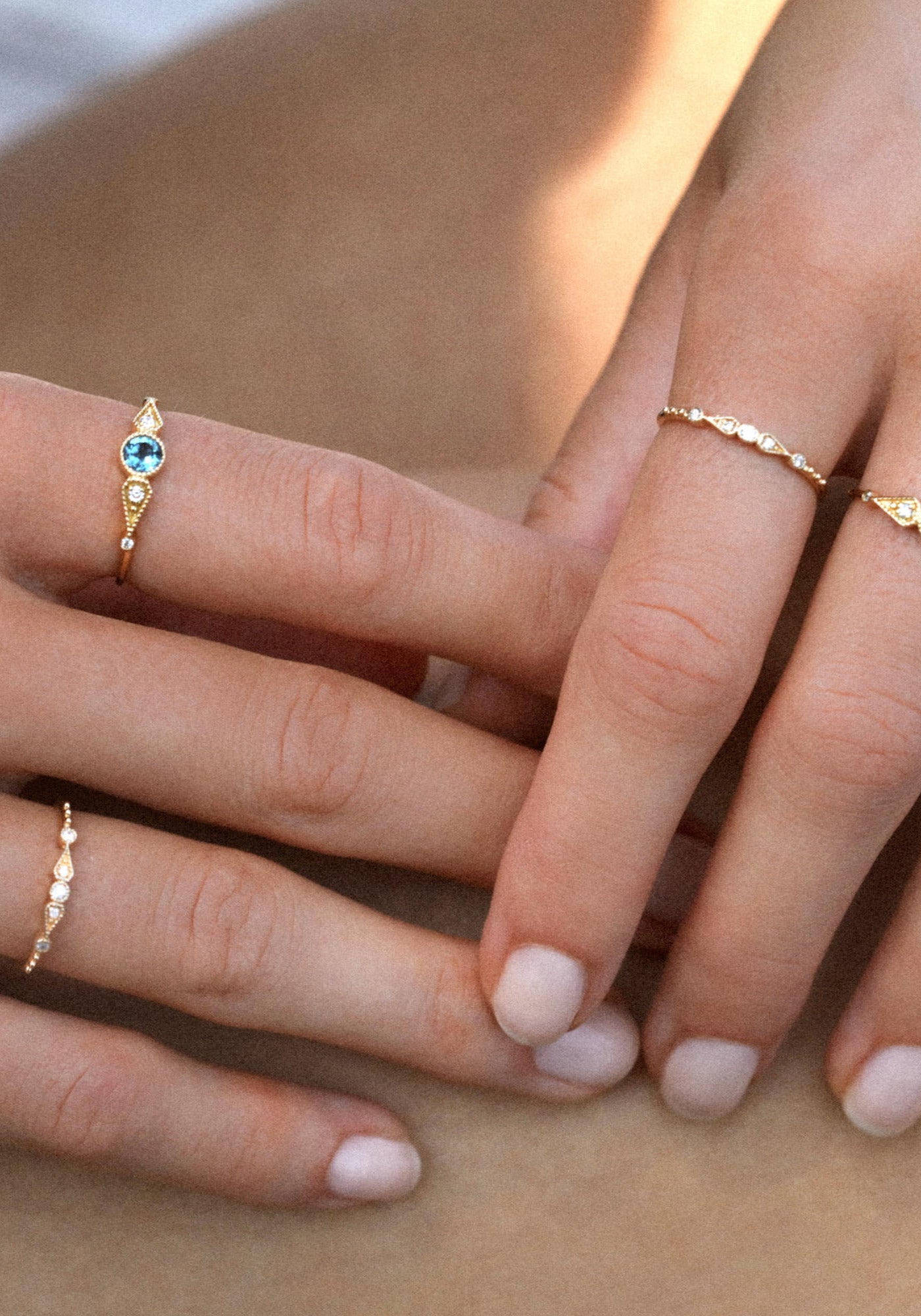 La femme porte la bague Stella 5 Diamants en or jaune de chez Angèle Brousse au niveau de son index et de son annulaire.