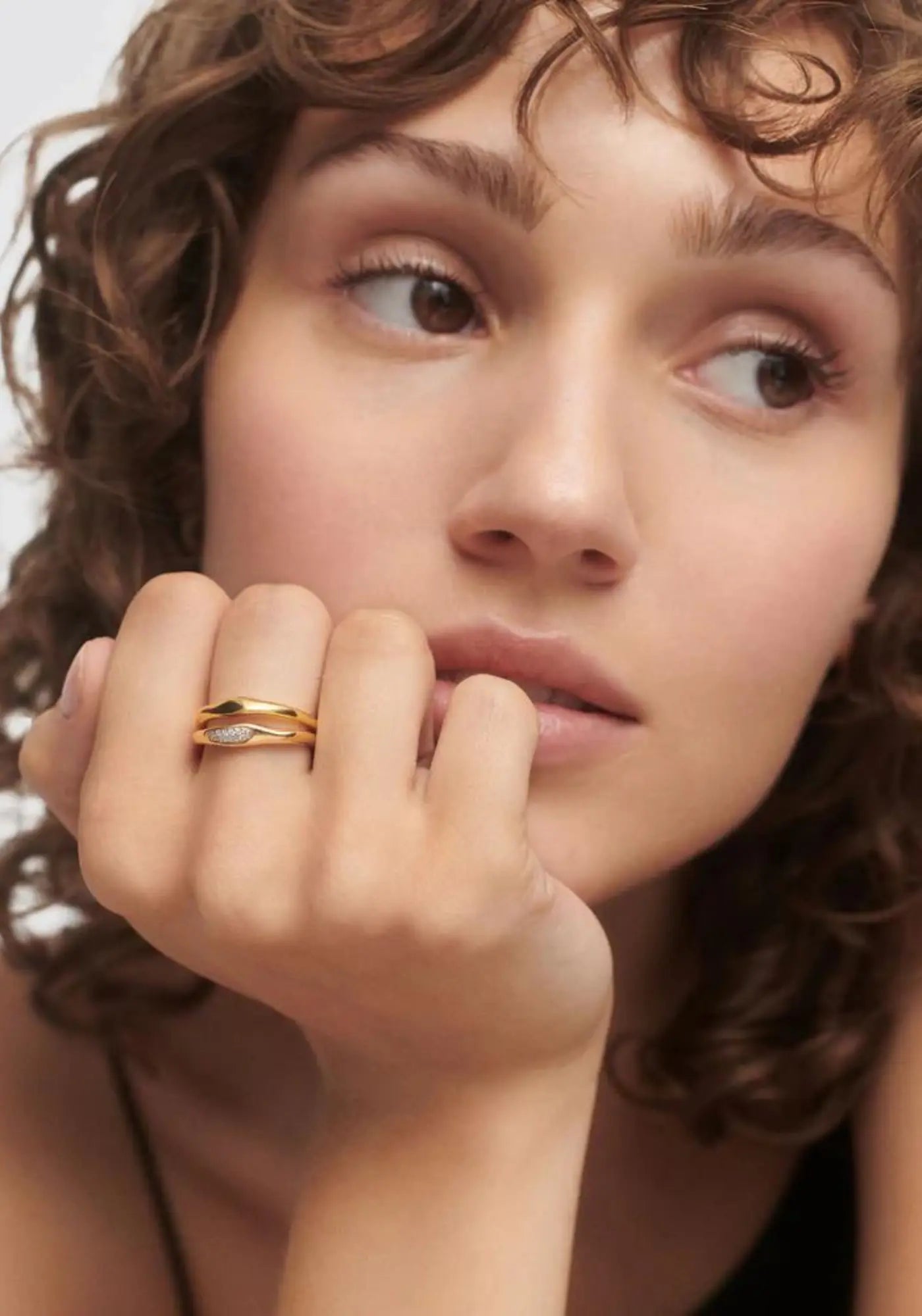 La femme porte les bagues Onda en or jaune 18 carats de chez PD Paola