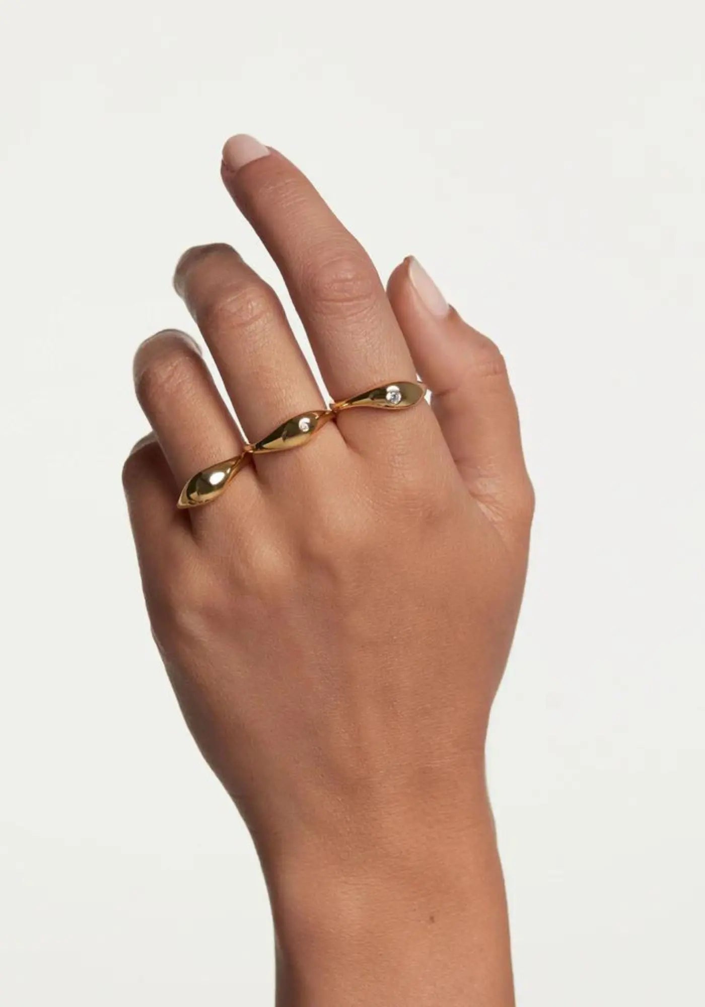 La femme porte les bagues Sugar en or jaune 18 carats de chez PD Paola