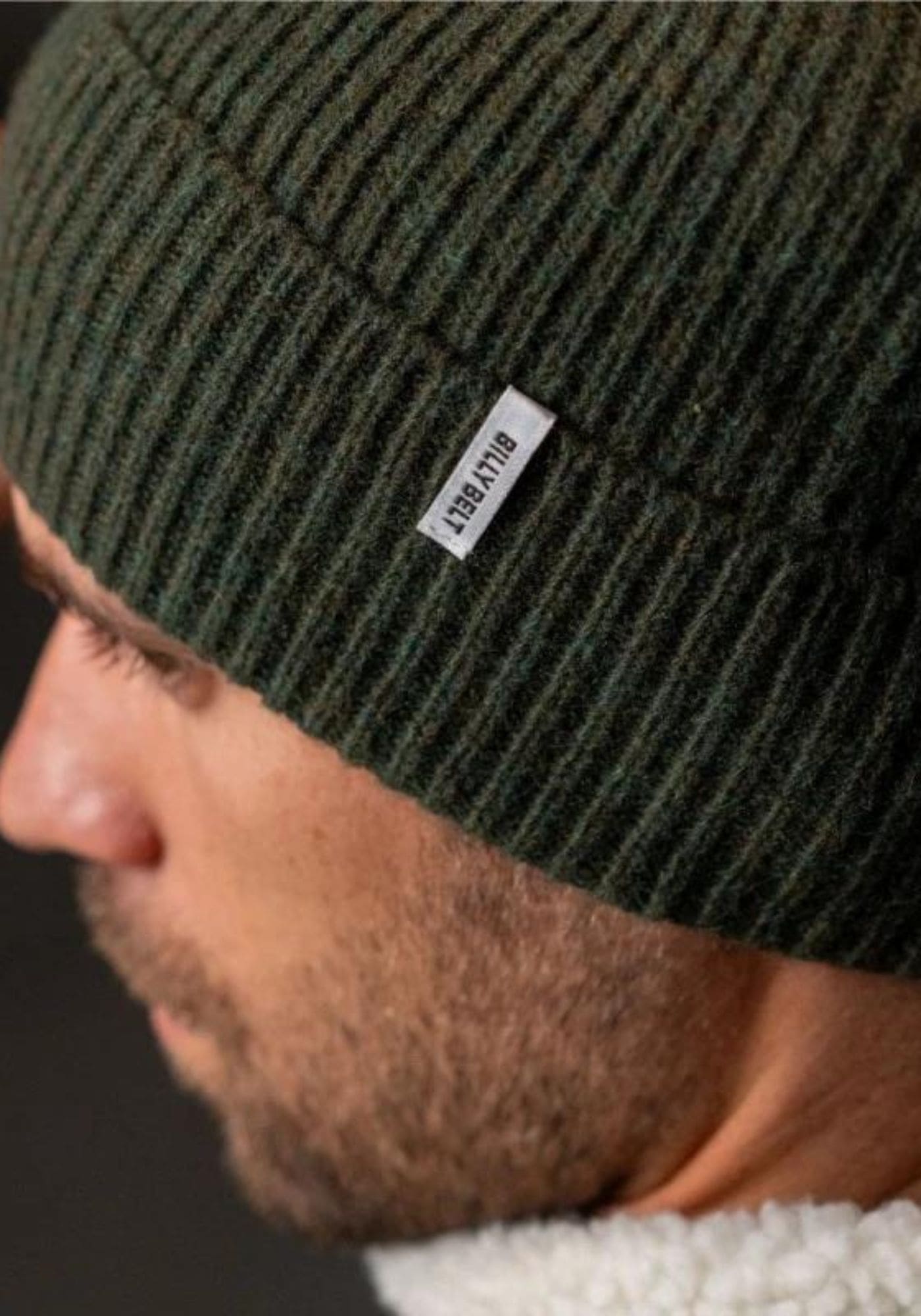 L'homme porte le bonnet en laine vert kaki de chez Billybelt