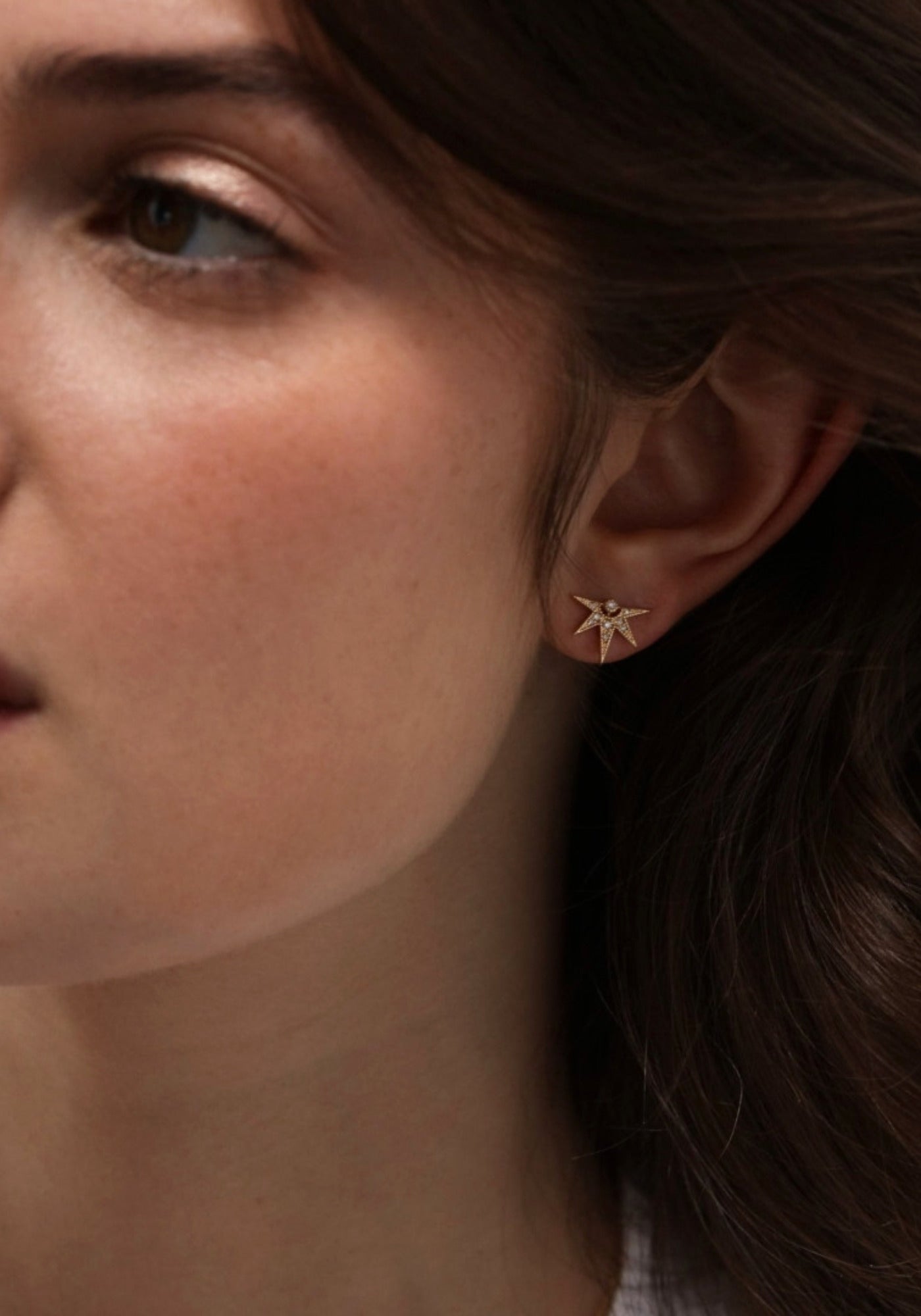 La femme porte la boucle d'oreille puce en or jaune Janis de chez Angèle Brousse