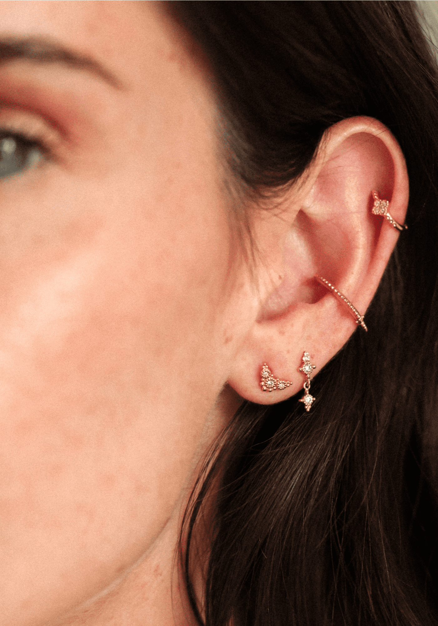 La femme porte la boucle d'oreille Puce Susie en or jaune de chez Angèle Brousse