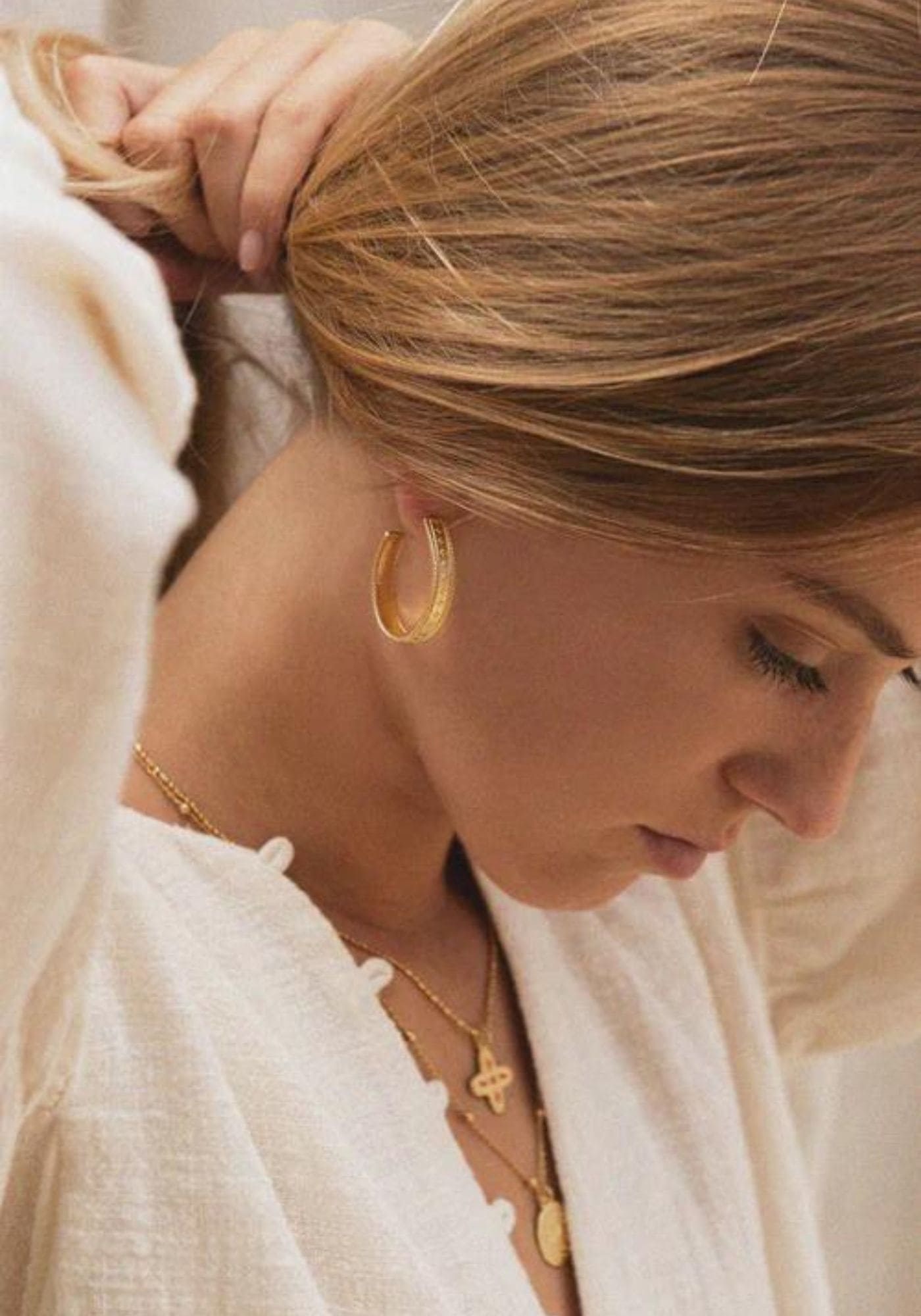 La femme porte les boucles d'oreilles Chiara de chez Bacci Paris