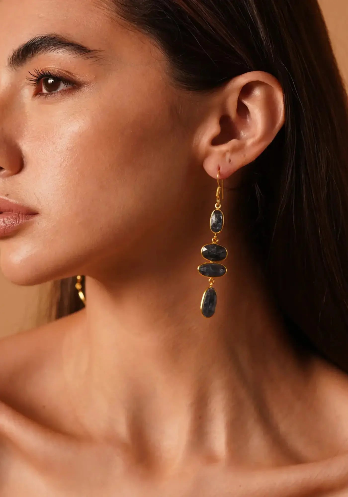 La femme porte les boucles d'oreilles Seafarer's Path bleu kyanite mousse de chez Ekadori