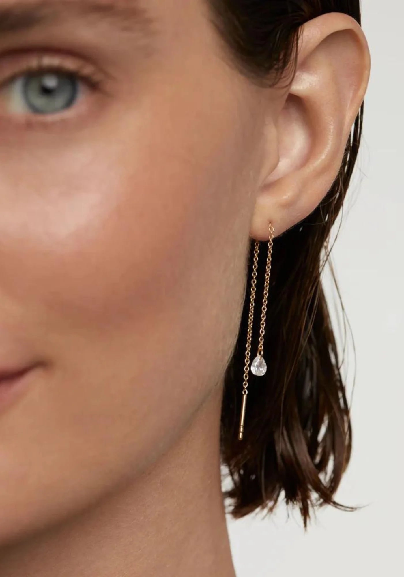 La femme porte les boucles d'oreilles Waterfall en or jaune 18 carats de chez PD Paola
