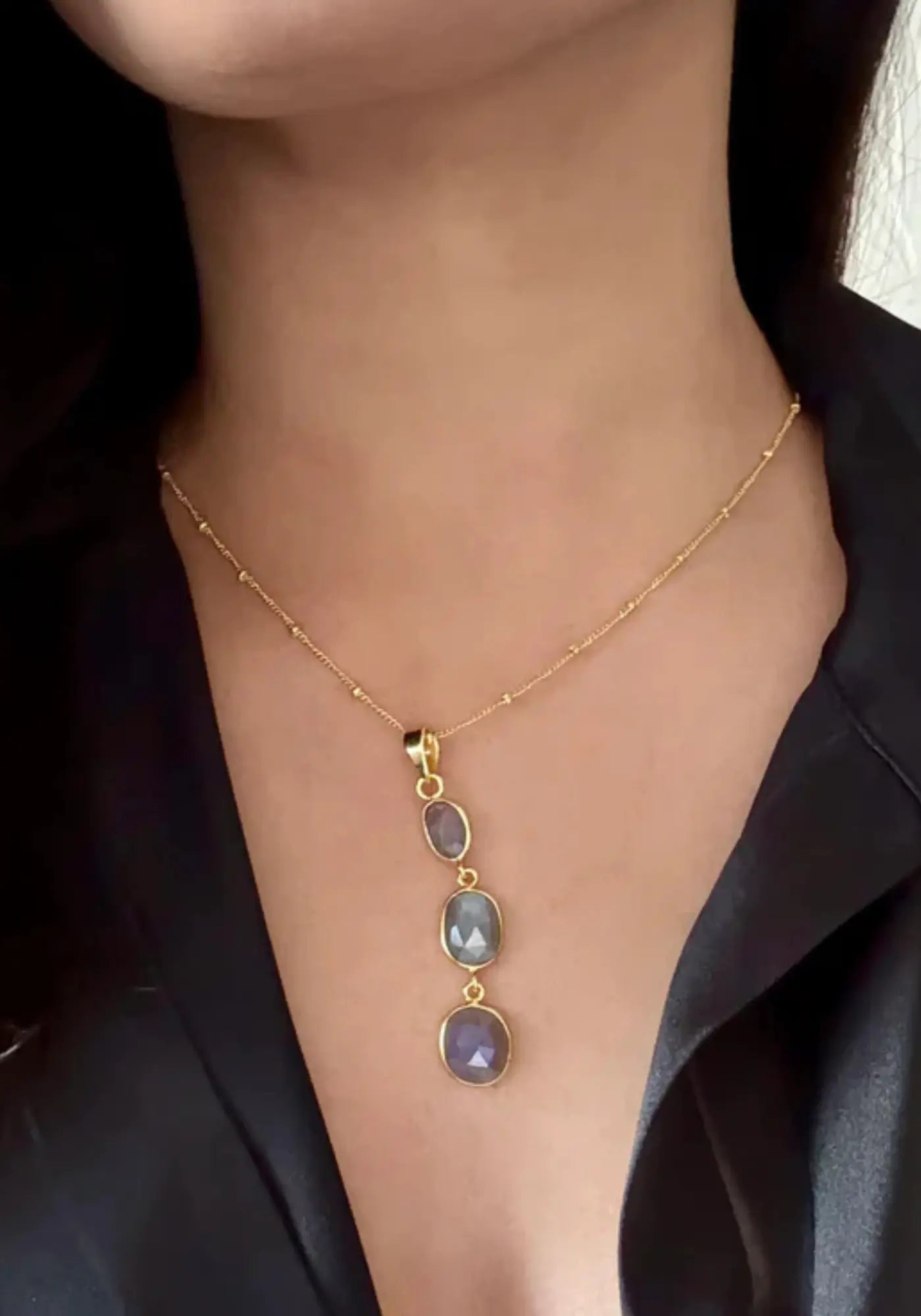 La femme porte le collier moonlit waters gris labradorite de chez Ekadori