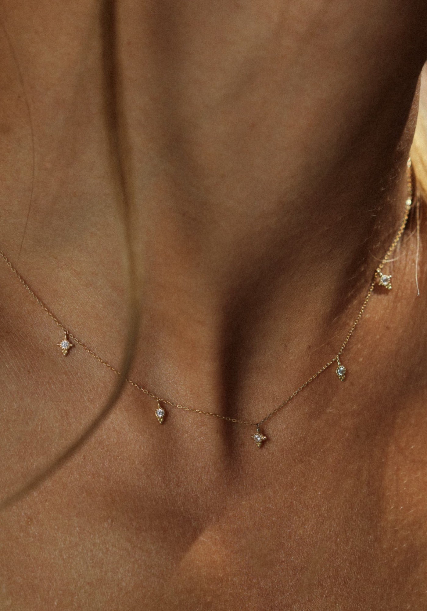 La femme porte le collier Paradis en or jaune de chez Angèle Brousse