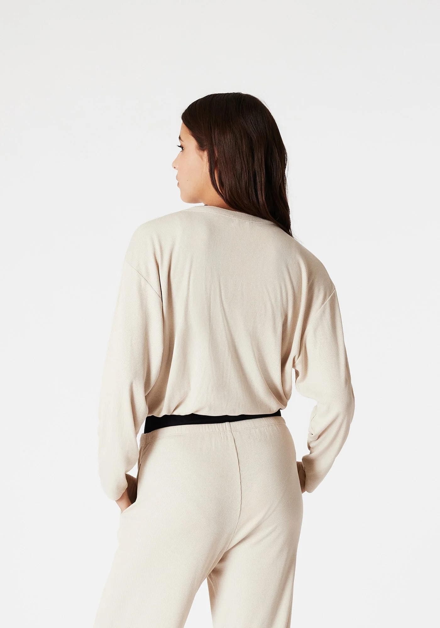 La femme porte le haut de pyjama Elise en lin de chez Icone, vue de dos