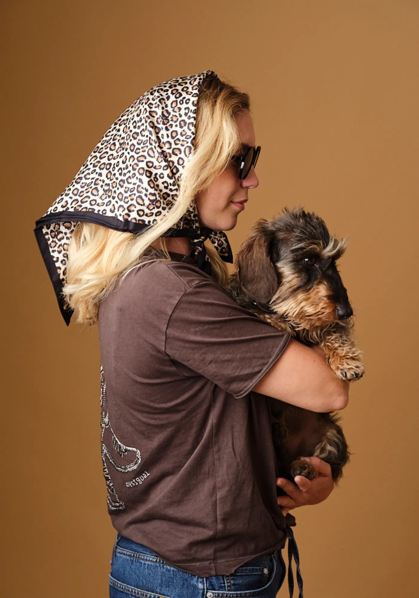 La femme porte le foulard léopard pure soie de chez Emily's Pillow dans les cheveux