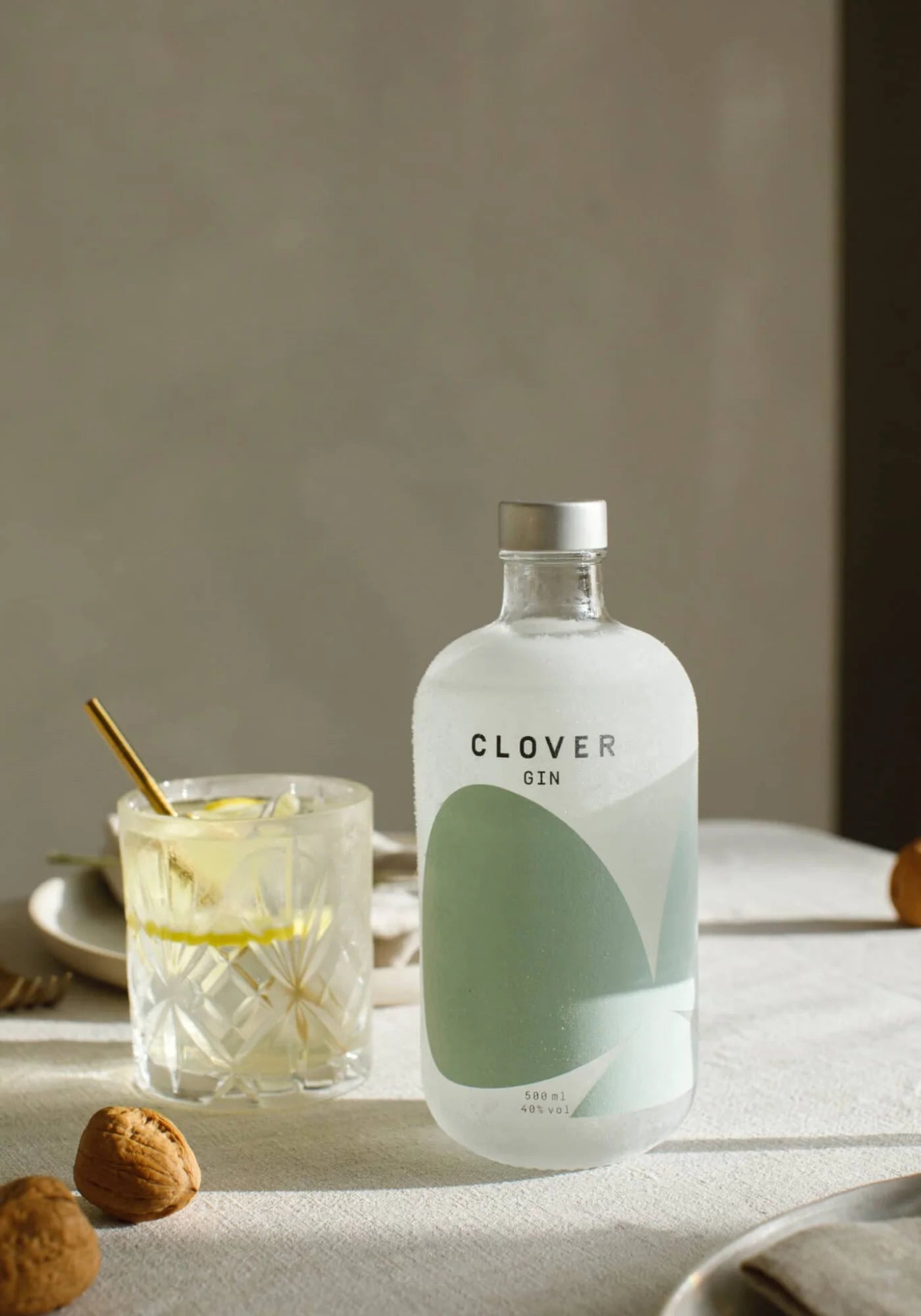 Le Gin Clover de chez Clover Gin accompagné d'un verre rempli et de noix
