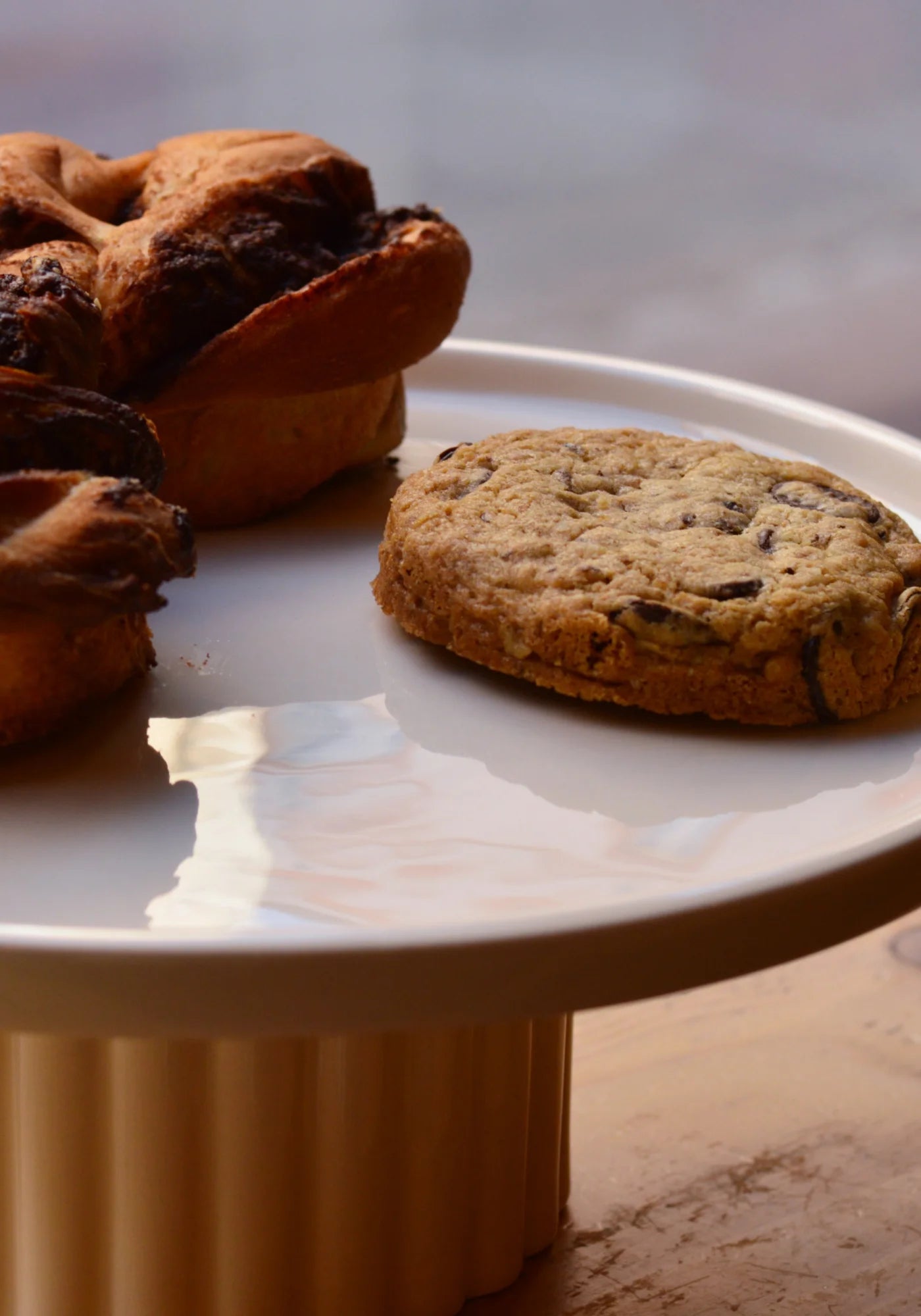 Le grand plateau en Grès beige de chez Maison Marah avec des gâteaux posés dessus