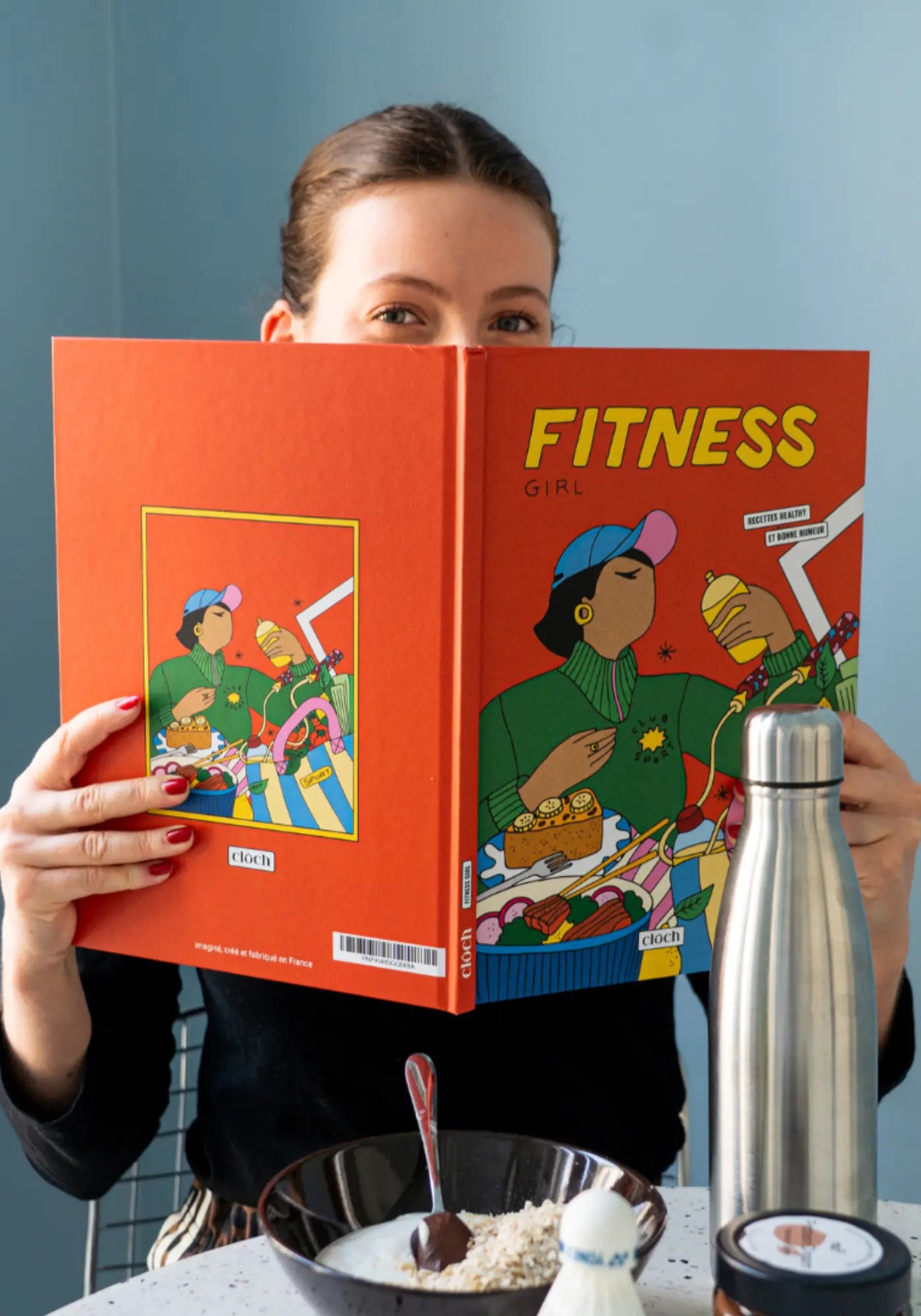 La femme tient le livre de recettes firness girl de chez Cloch