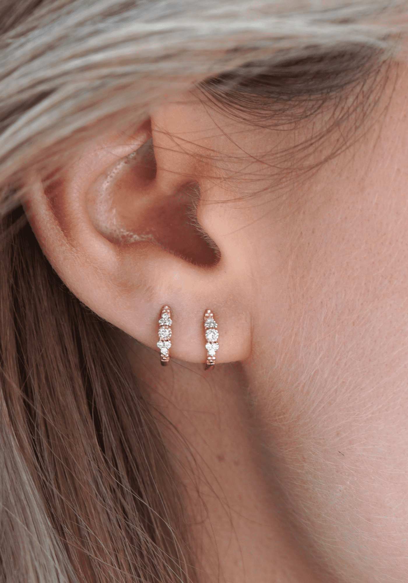 La femme porte la mini créole Paradis en or jaune de chez Angèle Brousse