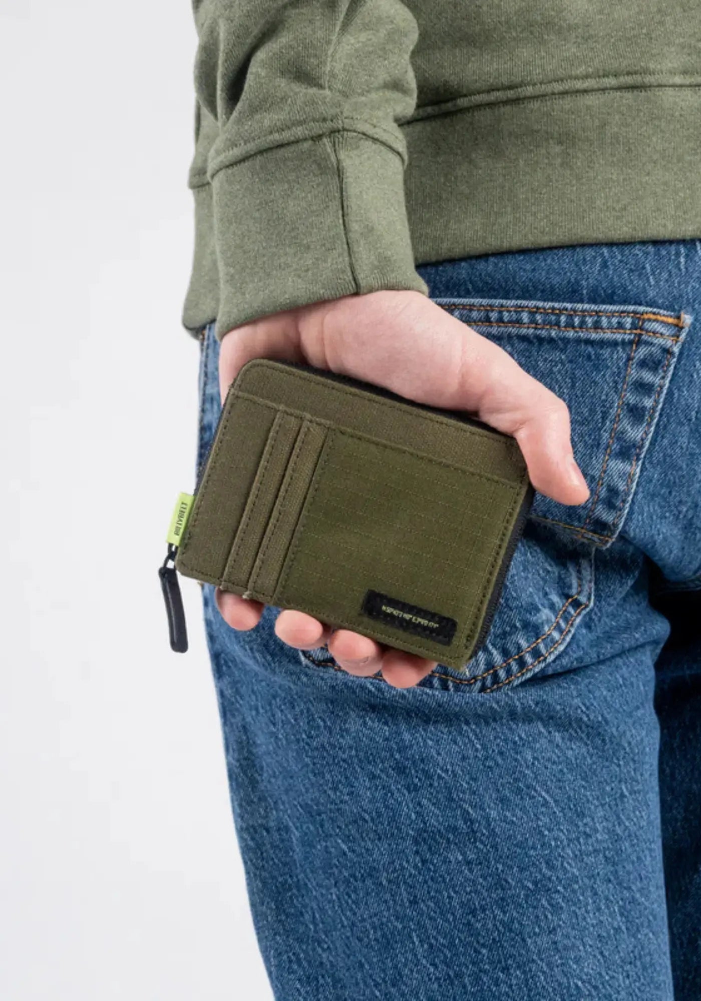 L'homme porte le portefeuille kaki de chez Billy Belt