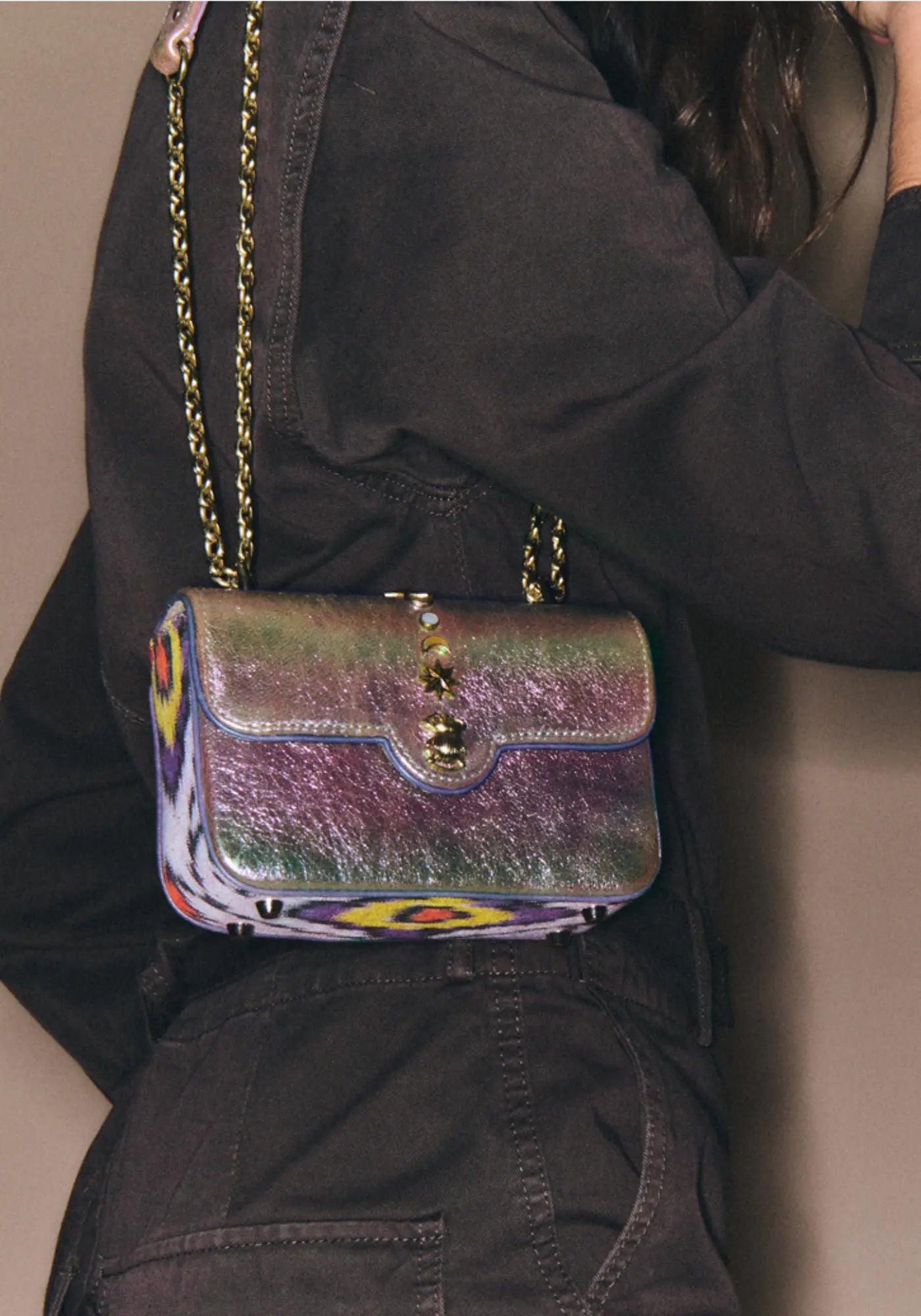 La femme porte le sac Mini Ava lune avec rivets en nacre de chez Claris Virot