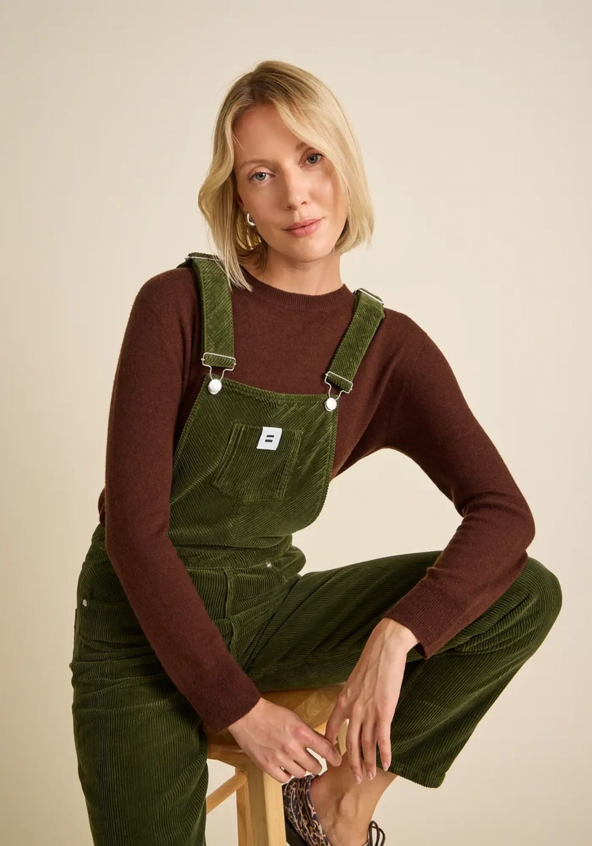 La femme porte la salopette mom coloris vert olive de chez Côtelé Paris