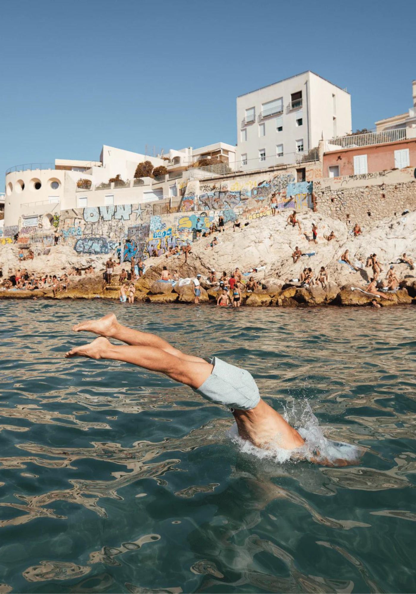 L'homme plonge dans la mer et porte le short de bain Napoli de chez Calanque