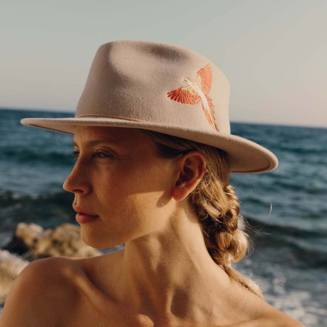 La femme porte sur la photo le chapeau Dakota de chez Van Palma en beige avec sa broderie 