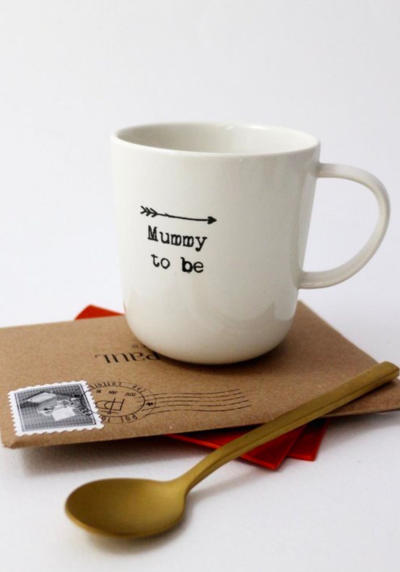 Le mug à message en faïence "Mummy to be" de chez Sophie Masson est posé sur une enveloppe