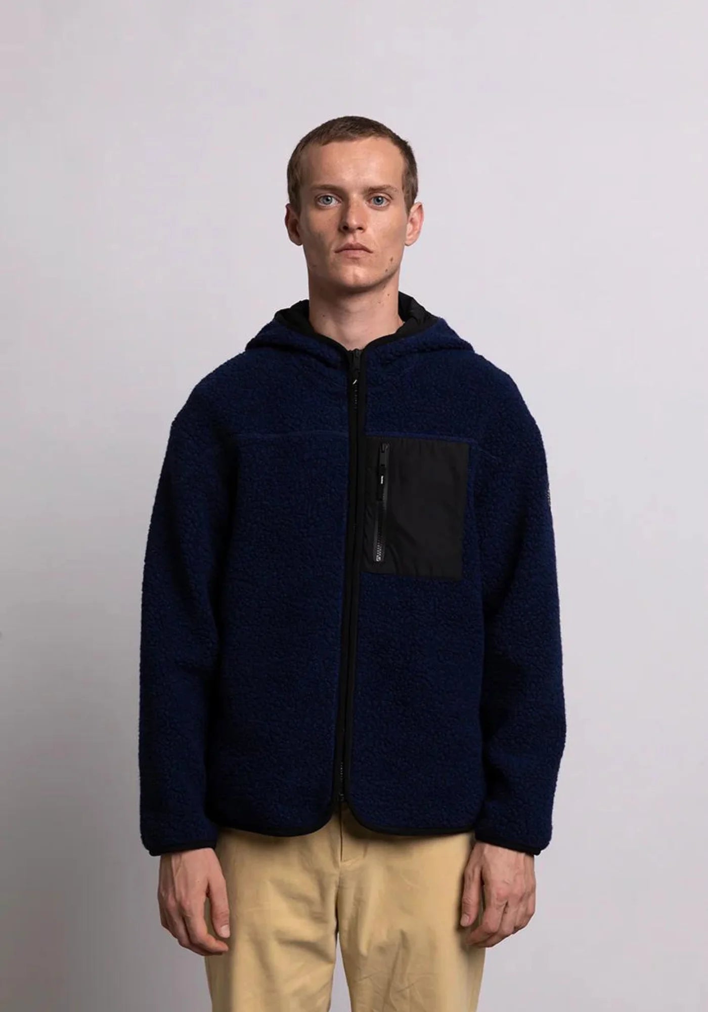 l'homme porte la veste sherpa unisexe hood bleu marine de chez mout mout 