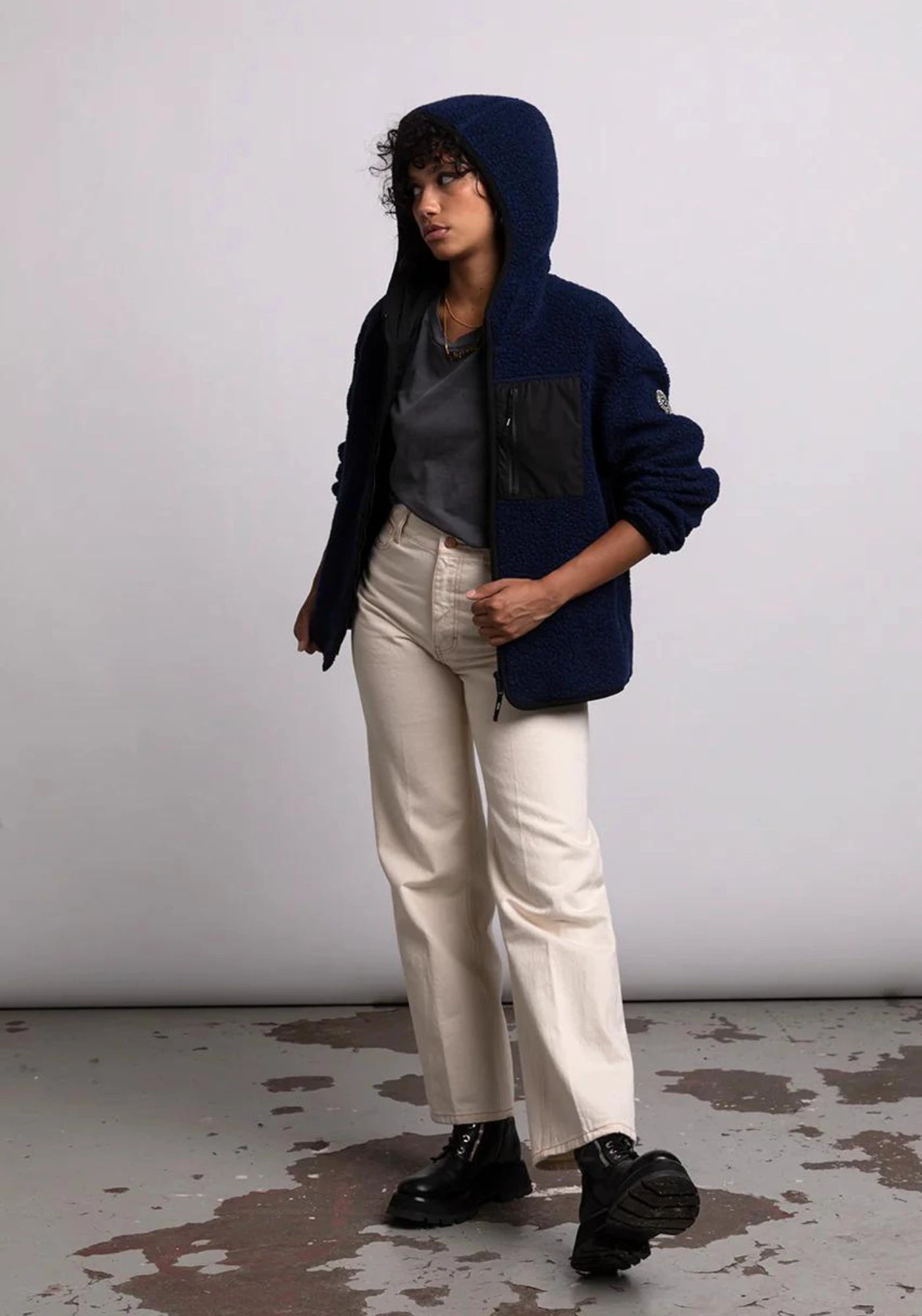 la femme porte la veste sherpa unisexe hood bleu marine de chez mout mout 