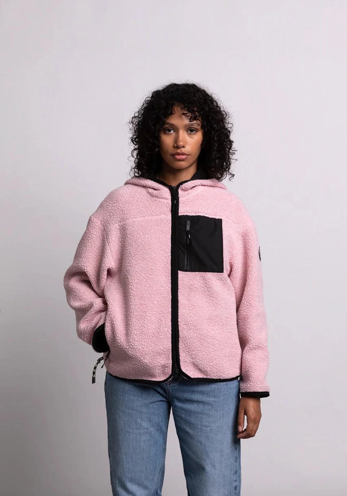 zoom sur la femme qui porte la veste sherpa unisexe hood rose cde chez mout mout 