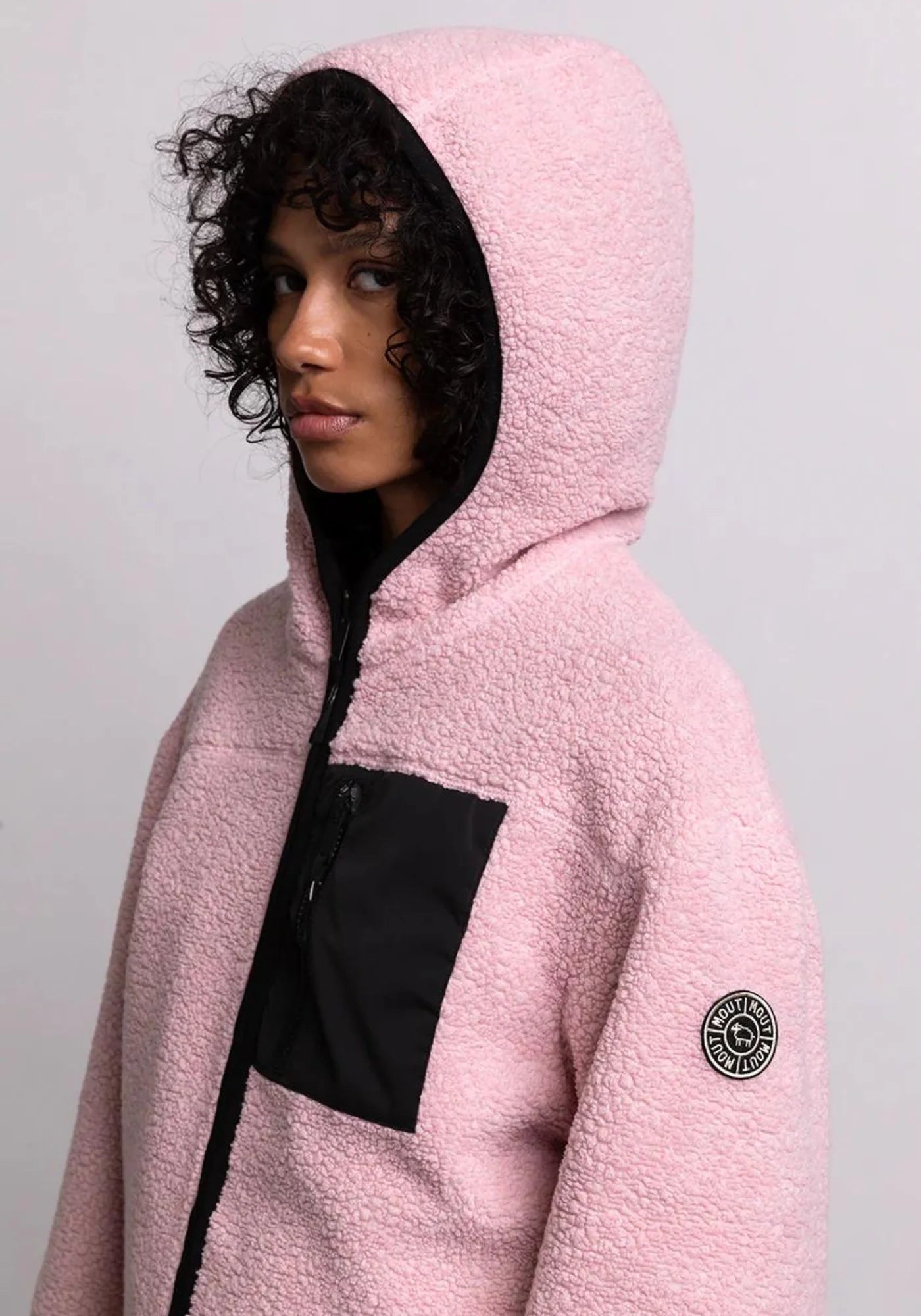 zoom sur la femme qui porte la veste sherpa unisexe hood rose cde chez mout mout 