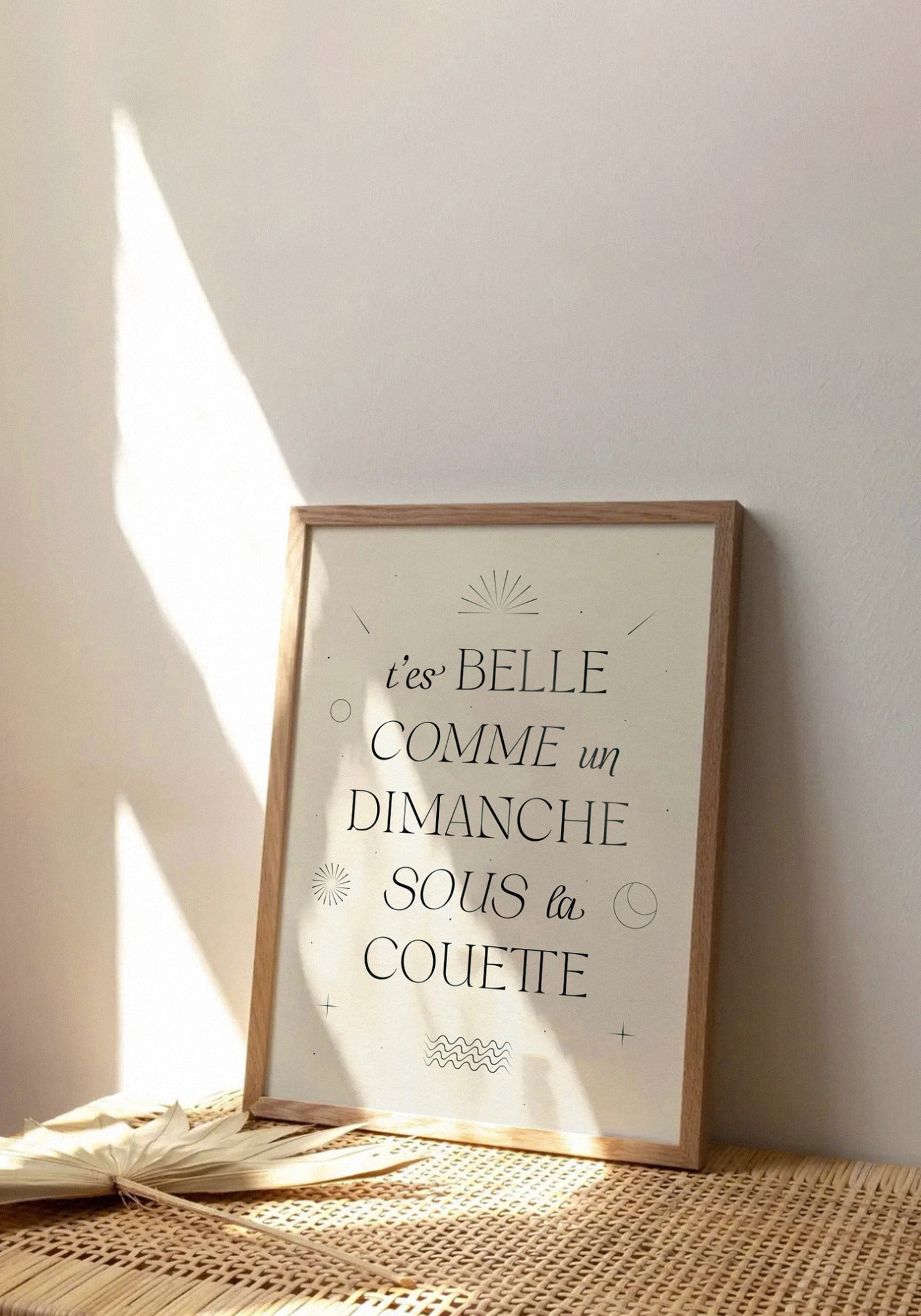 L'affiche typographique "T'es belle comme un dimanche sous la couette" en 21x30 cm de chez Studio Topo posée sur un banc en bois