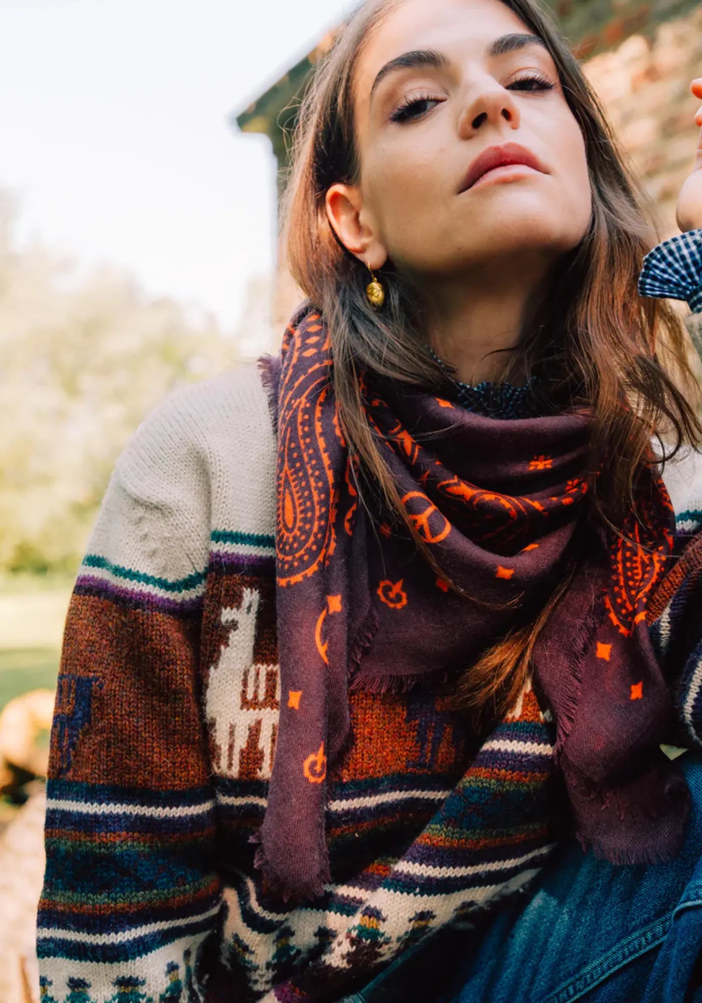 La femme porte le bandana laine 100 fudge flame de chez Antan Créations