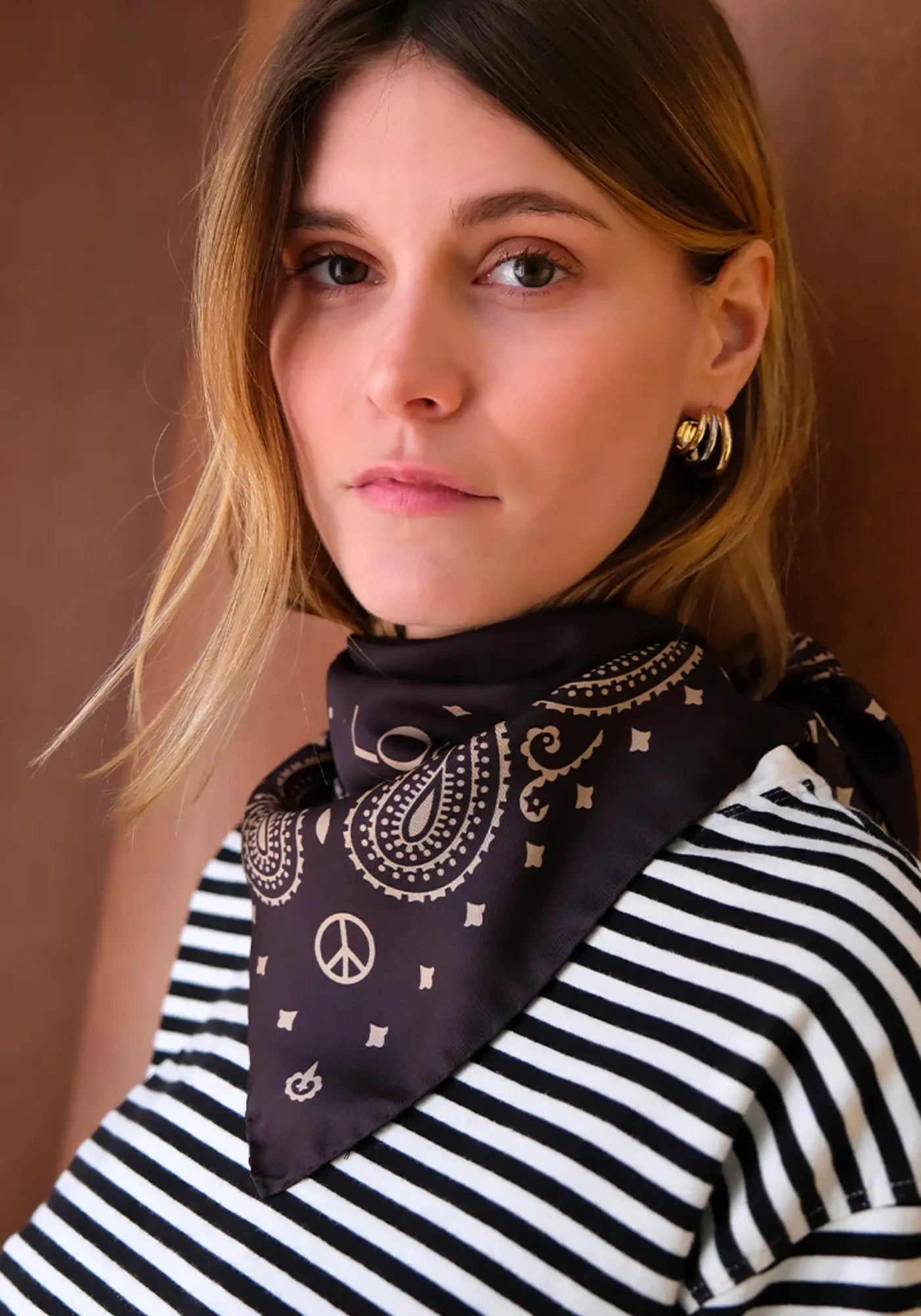 La femme porte la bandana silk 70 ganache nomad de chez Antan Créations