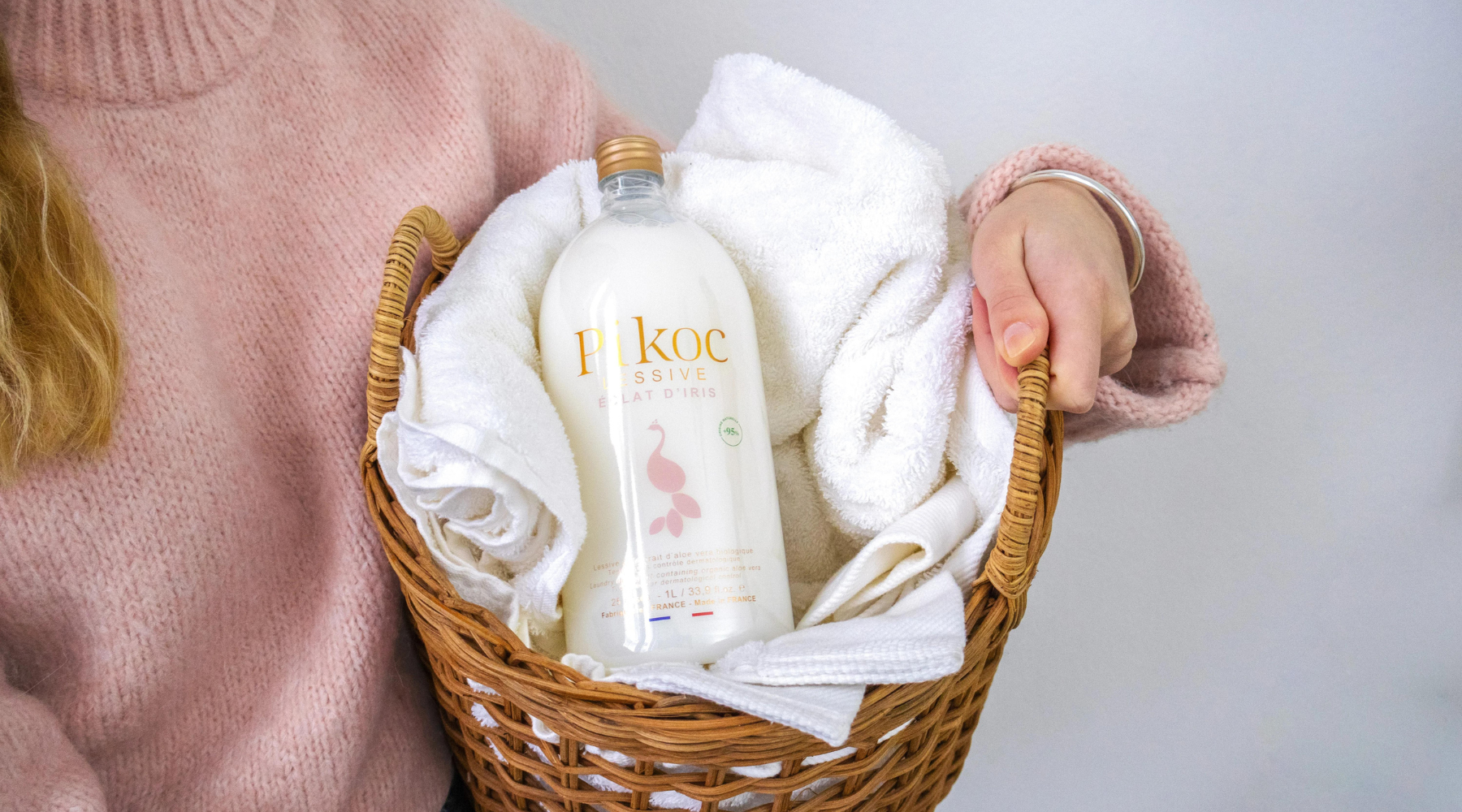 La femme porte un panier à linge avec la lessive Pikoc