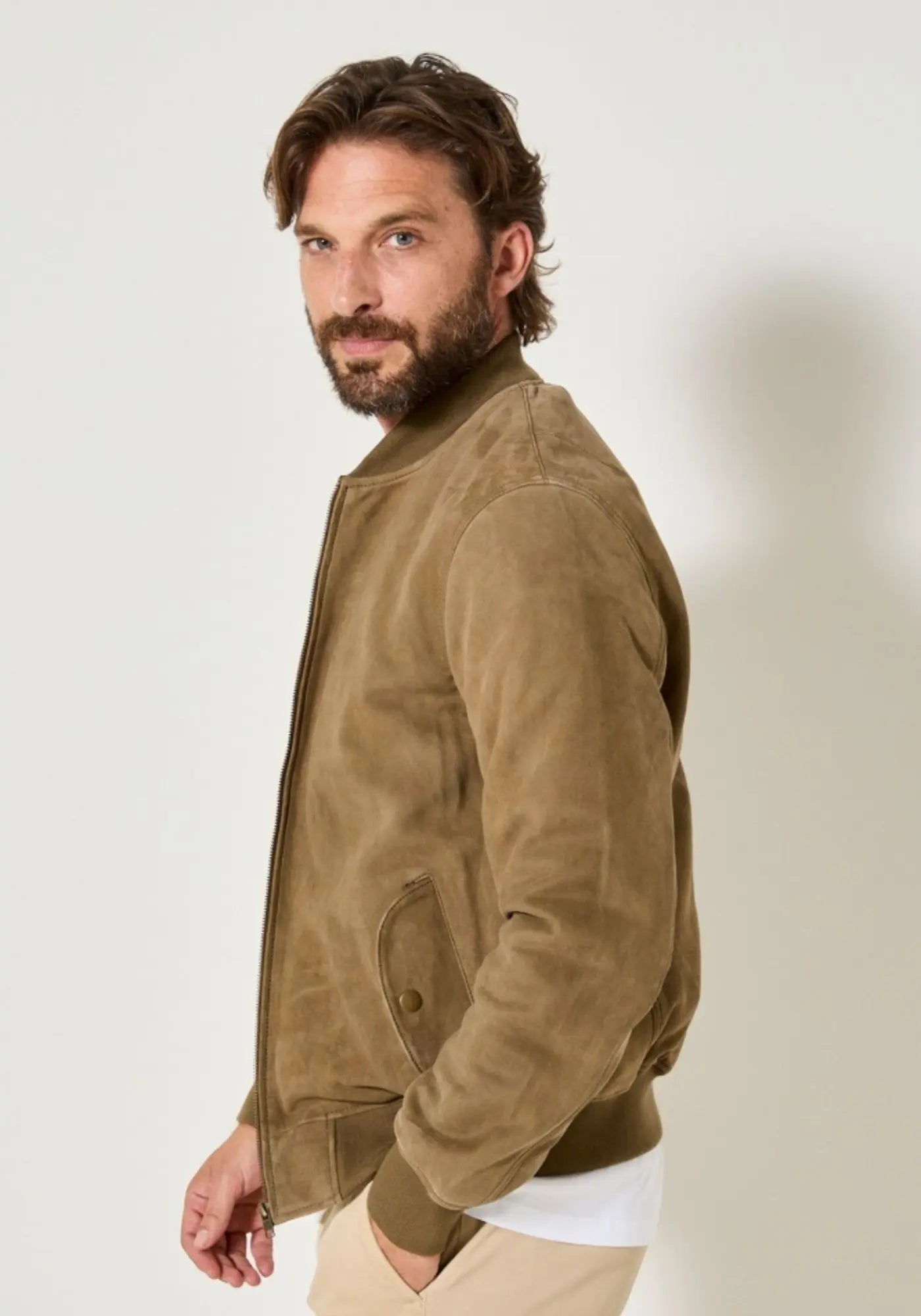 L'homme est de profil et porte le blouson en cuir Tonio couleur pistache de chez Jaqk 