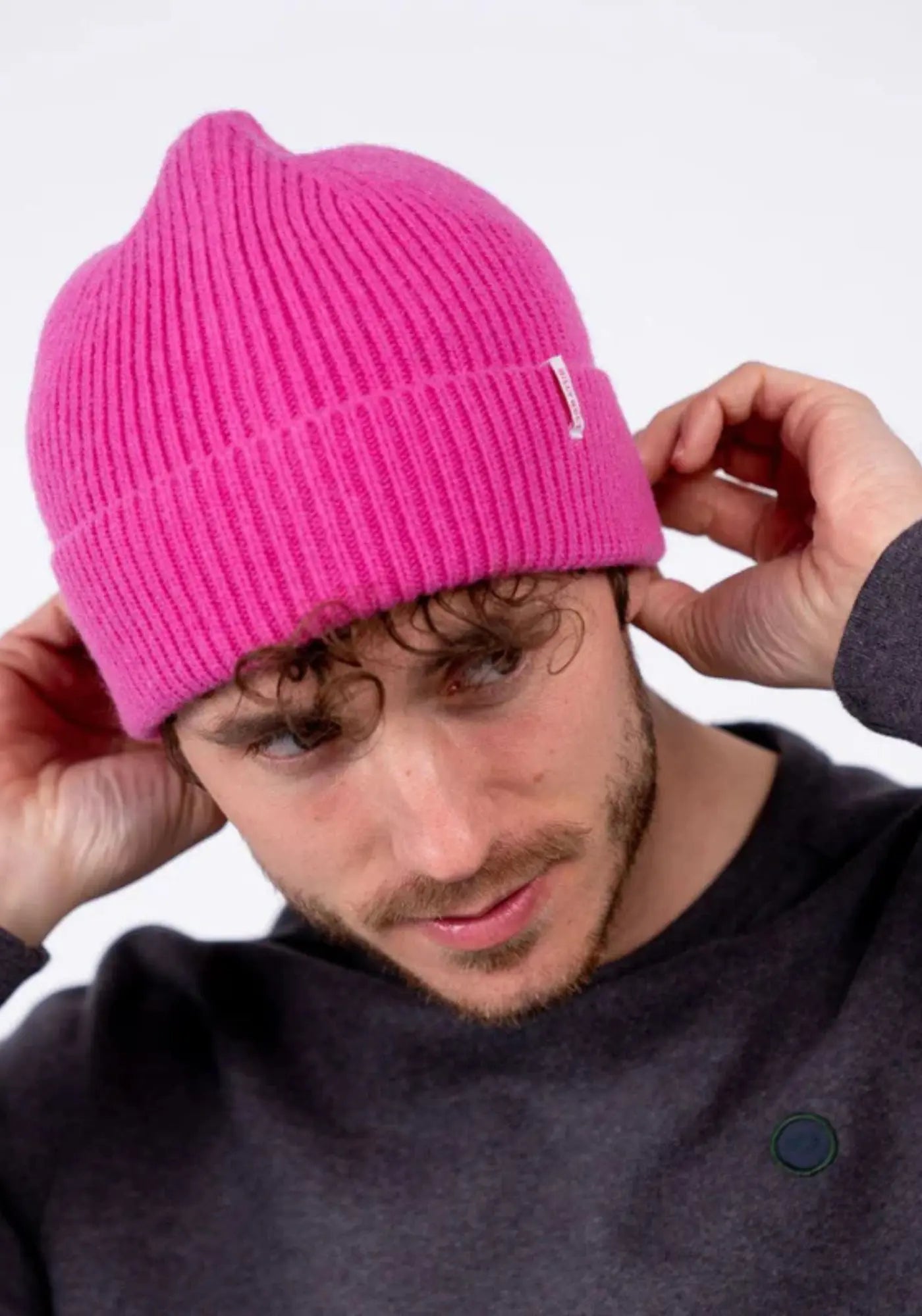 L'homme porte le bonnet en laine rose bubble gum de chez Billybelt