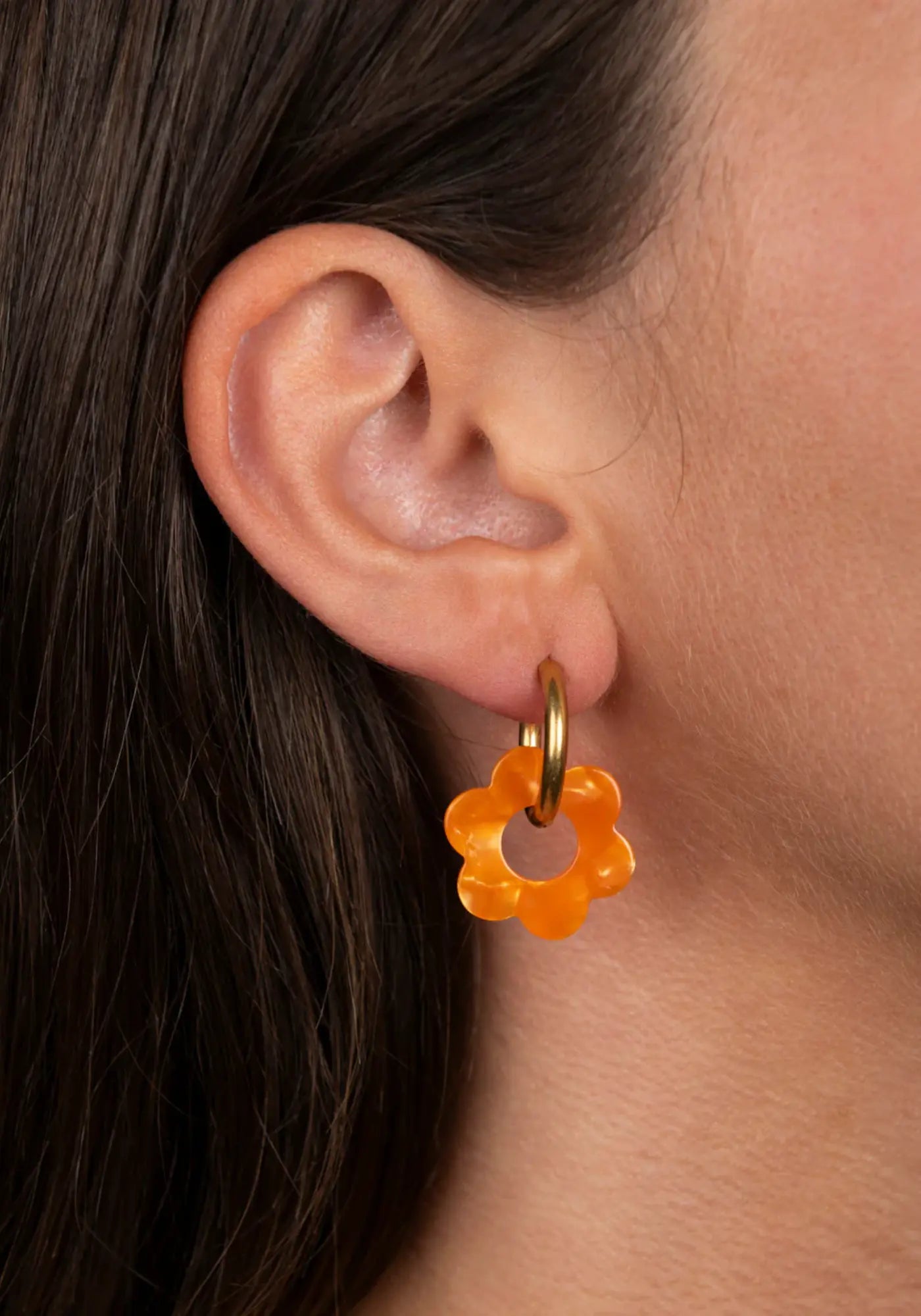 La femme porte les boucles d'oreilles fleurette clémentine baby de chez Kurage Ginza