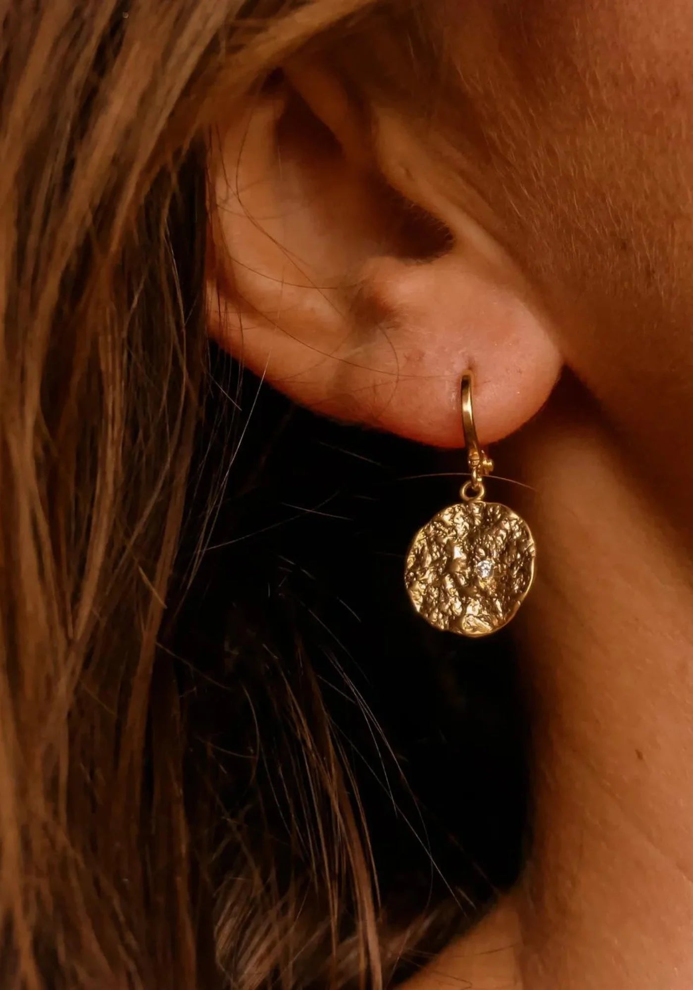 Zoom sur la femme qui porte les boucles d'oreilles Lucia de chez Maison Soleil