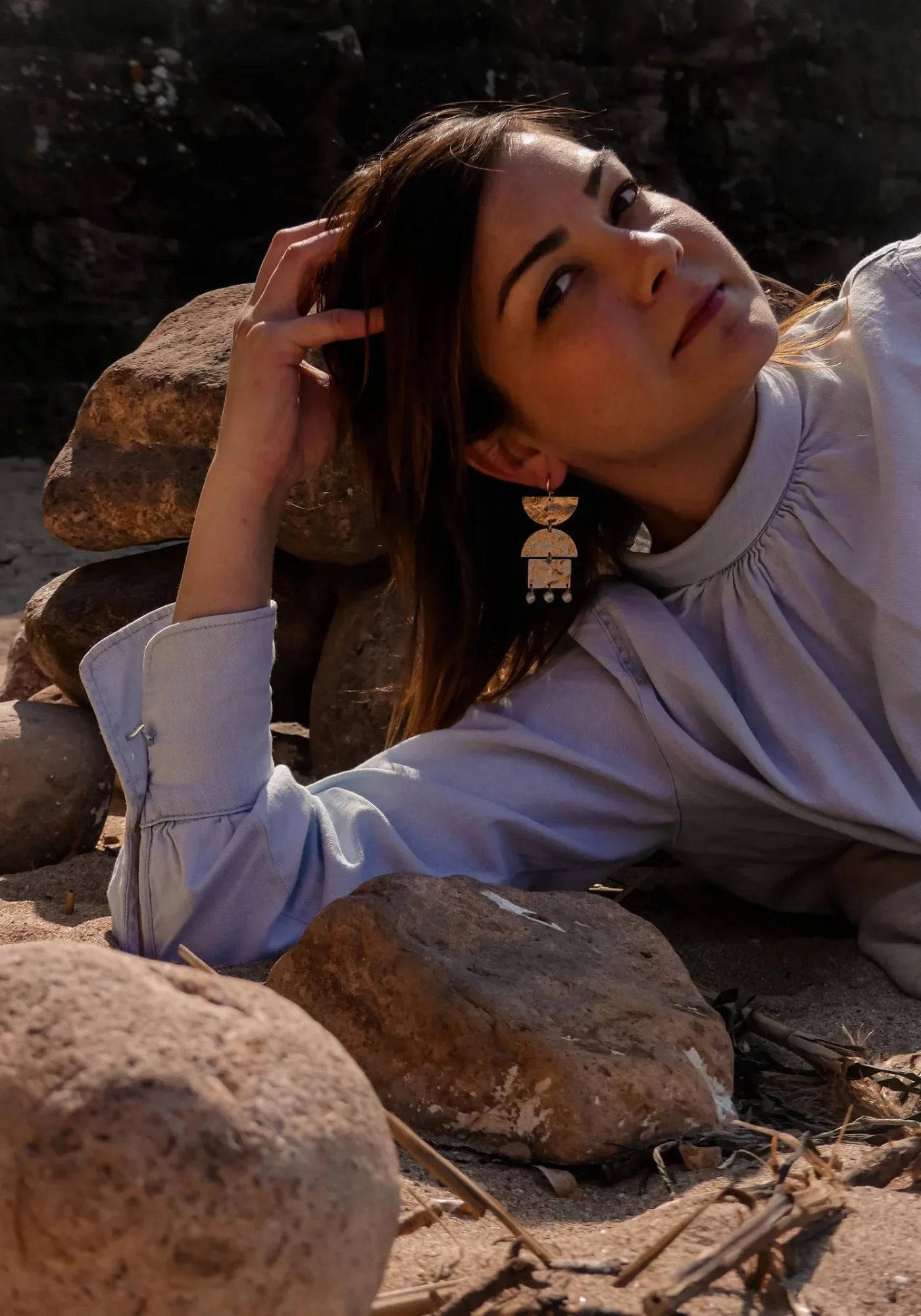 La femme porte les boucles d'oreilles Paloma de chez Maison Soleil