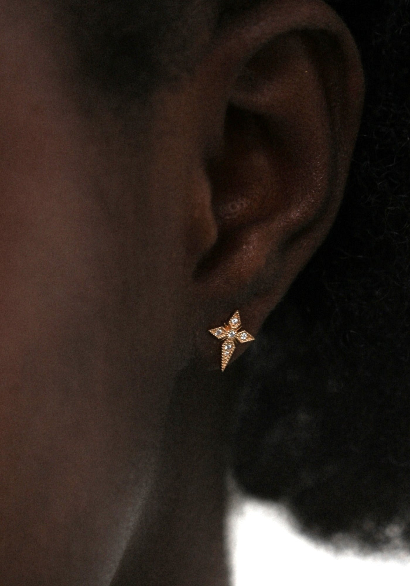 Zoom sur la boucle d'oreilles puce croix saintes pour femme en or jaune de chez Angèle Brousse