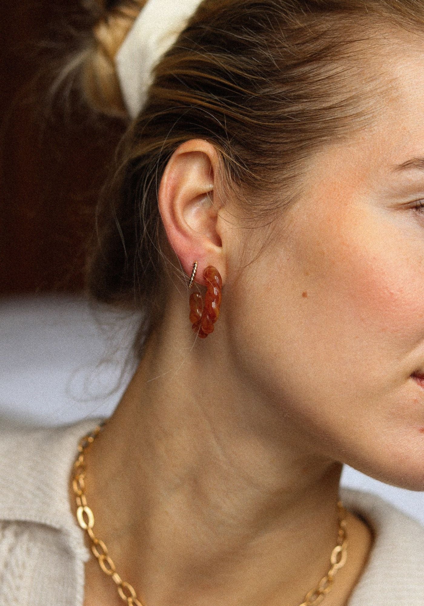 la femme porte les boucles d'oreilles Roma Caramelo. 