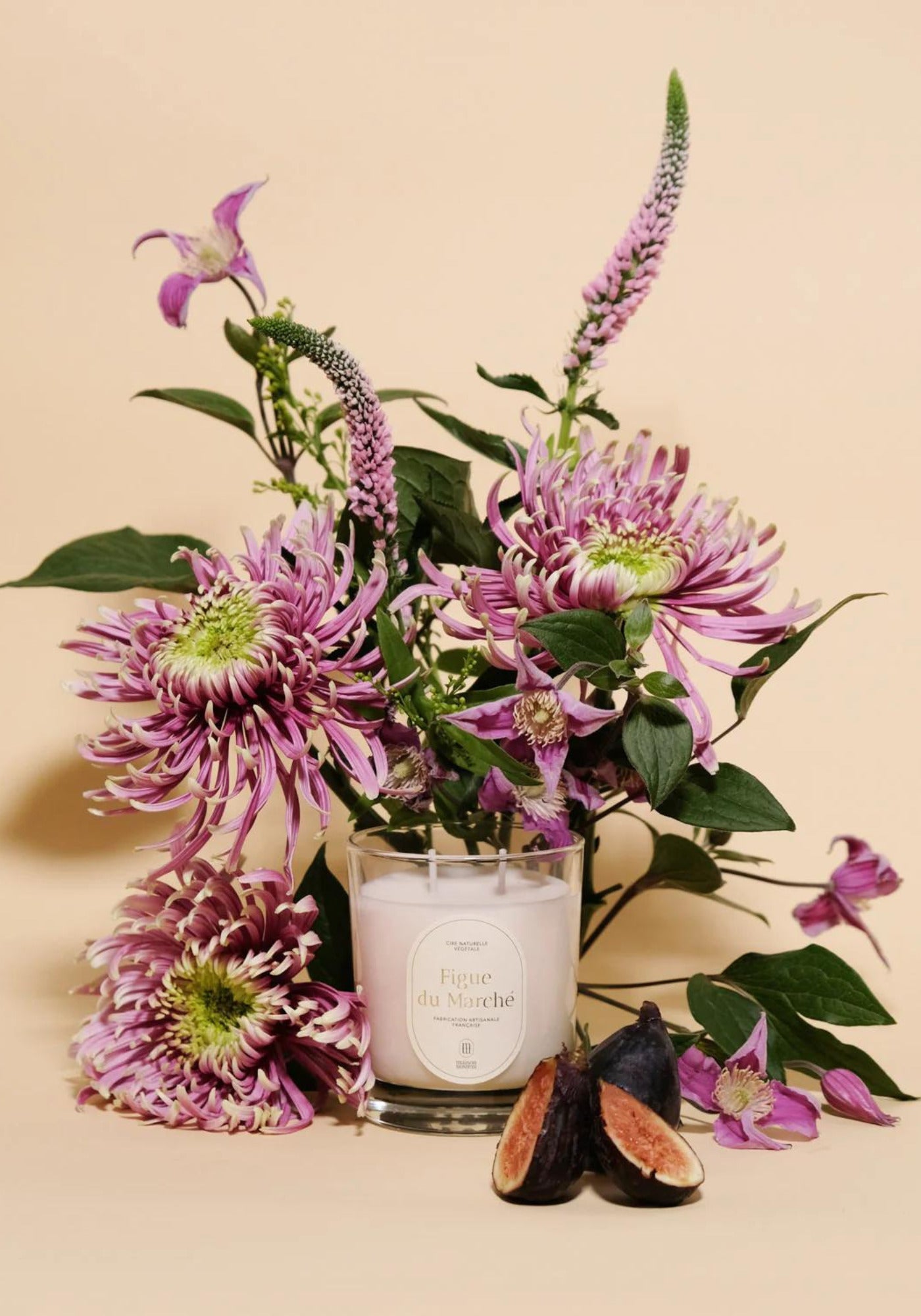 La bougie parfumée Figue du Marché de chez Maison Maison est entourée de fleurs et de figues