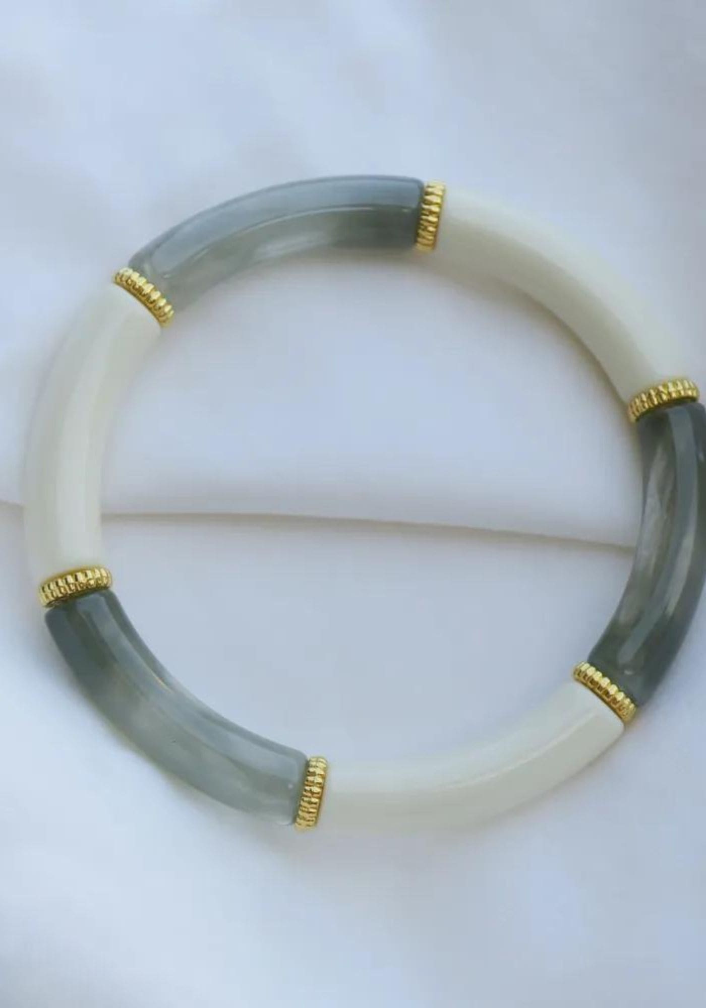 Le bracelet jonc Saint Raphael de chez Atelier Kat H est posé sur un drap blanc