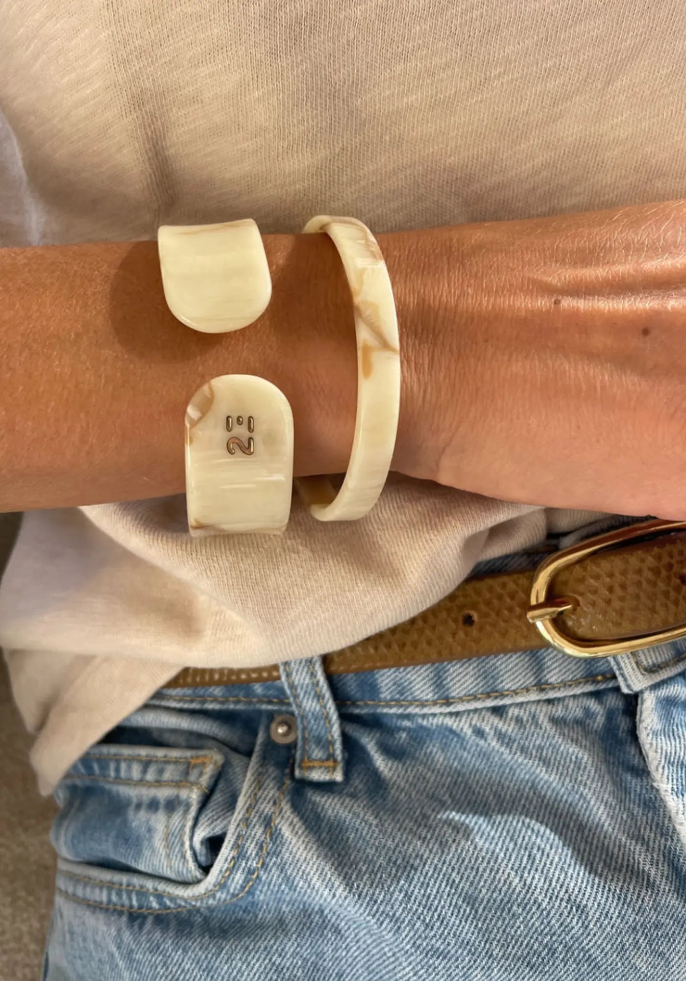 La femme porte le bracelet jonc ivoire fin et large de chez 23 Degres