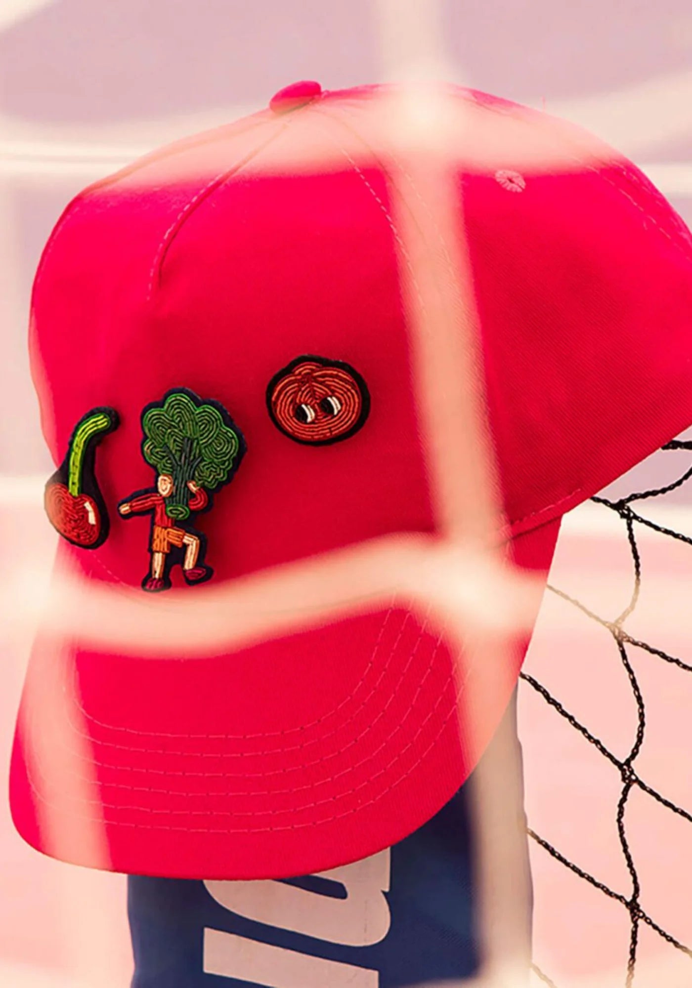 La broche brodée à la main Cherry Chérie de chez Macon & Lesquoy sur une casquette rouge