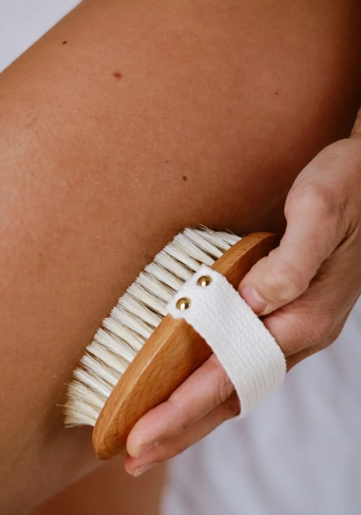 La femme utilise la brosse corps massage à sec de chez Bachca