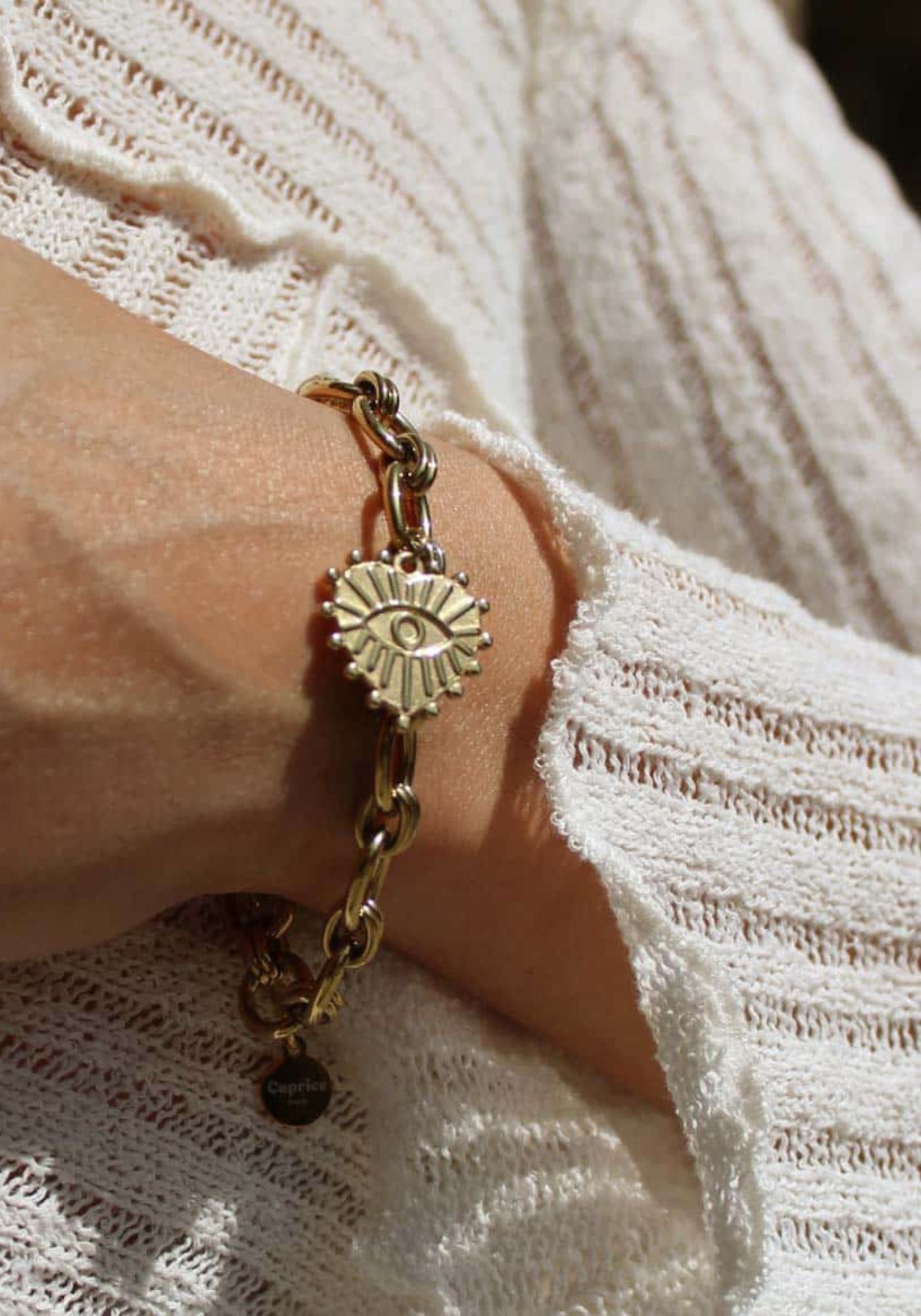 La femme porte le bracelet Judith en acier inoxydable doré de chez Caprice Paris