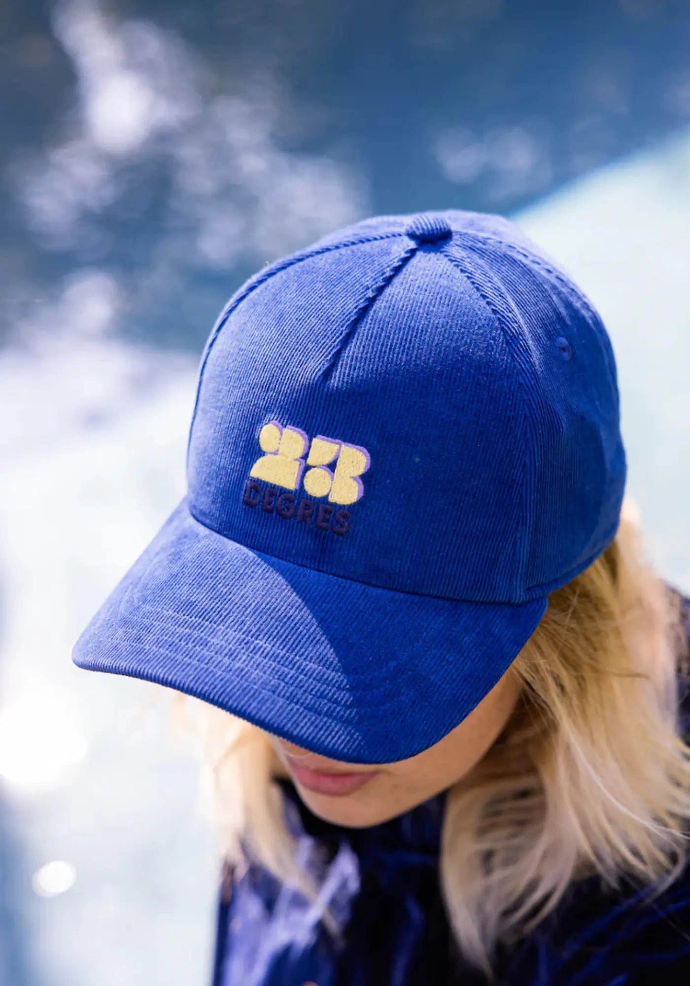 La femme porte la casquette bleu de chez 23 Degres