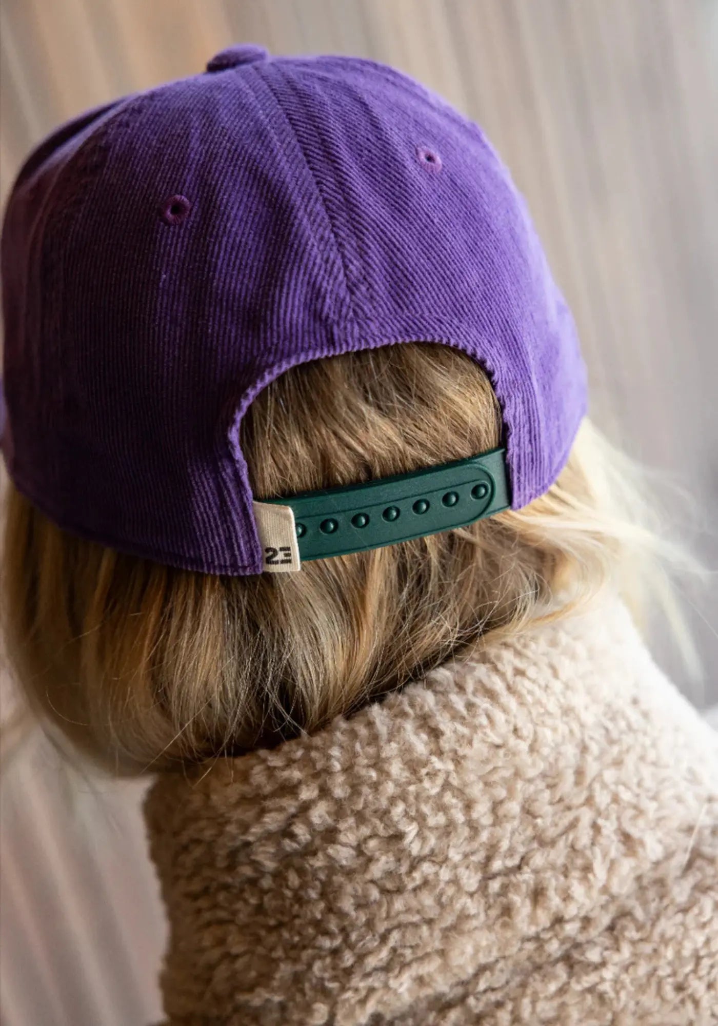 La femme est de dos et porte la casquette violette drop 1 de chez 23 Degres