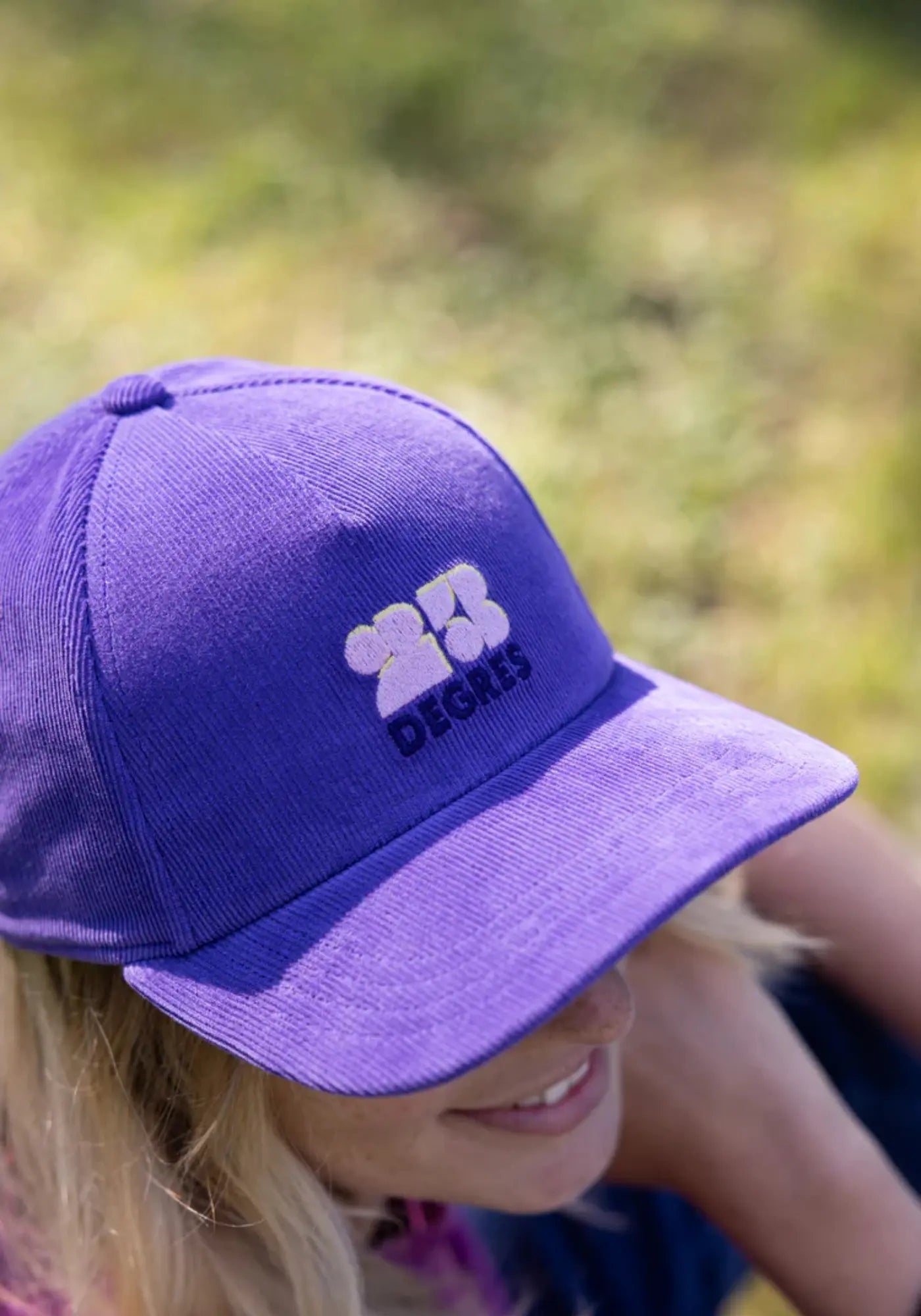 La femme porte la casquette violette drop 2 de chez 23 Degres