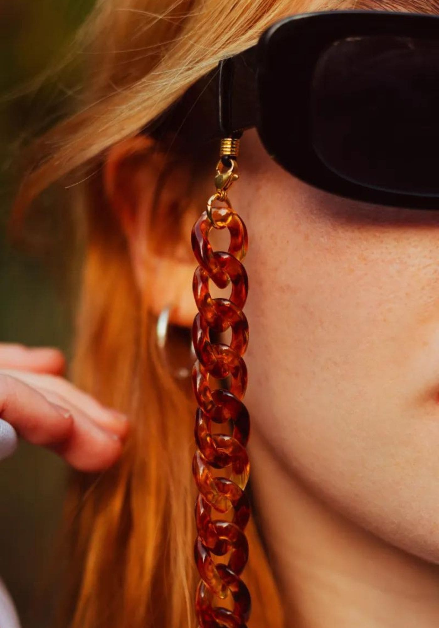 Zoom sur la chaîne de lunette en acrylique Hazel de chez Atelier Kat H sur les lunettes de soleil de la femme